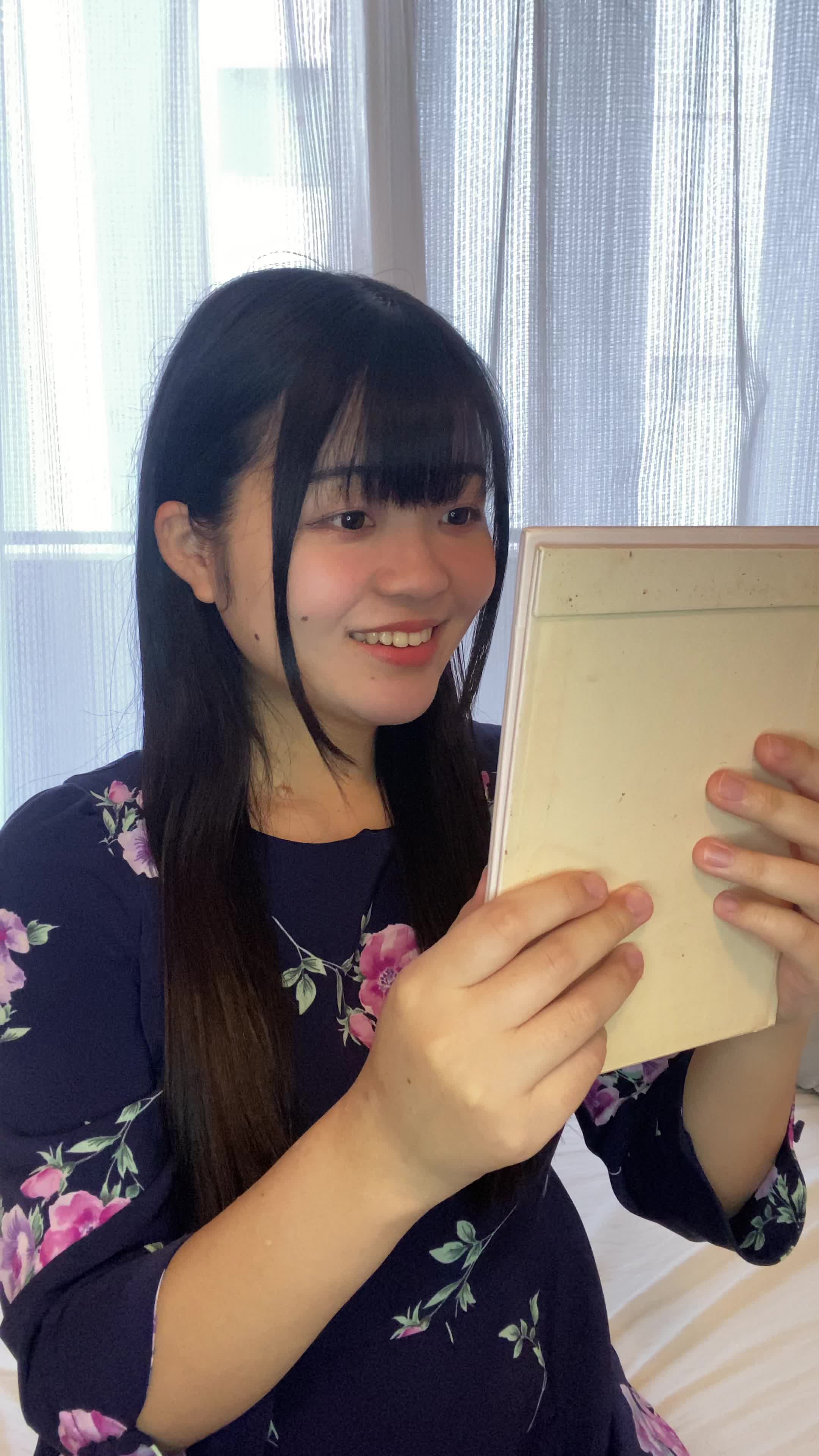 ソファで鏡を見ながら、「矯正後の自分を想像して」期待に胸を膨らませる姿