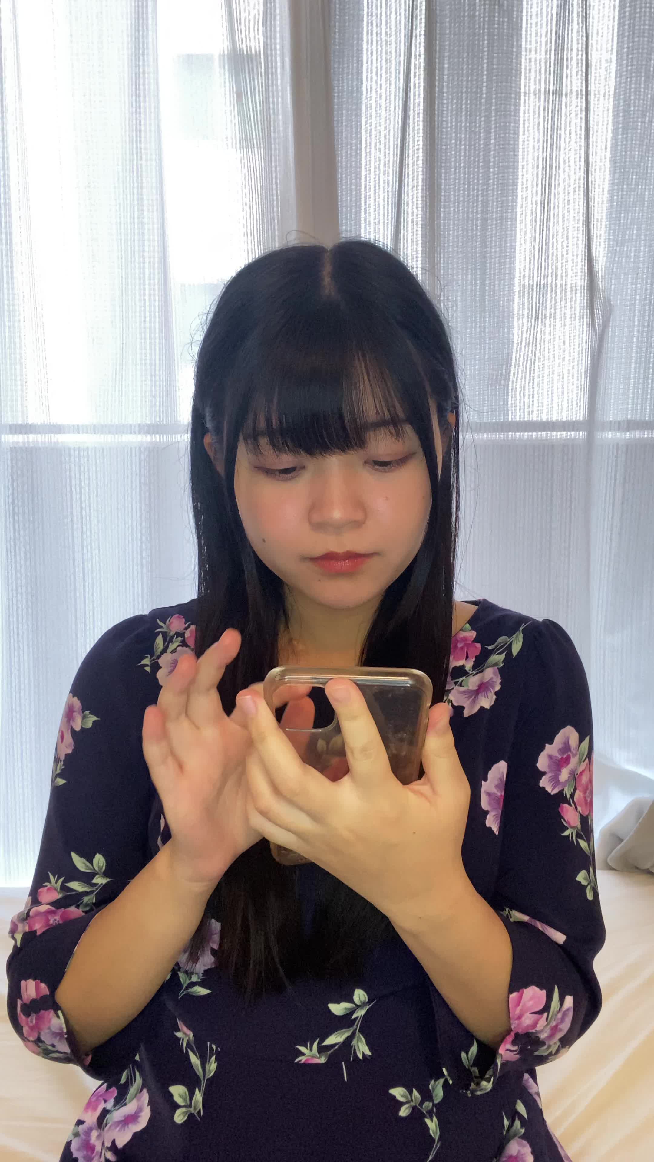 ソファでスマホを置き、「矯正を始める決意を固める」前向きな表情