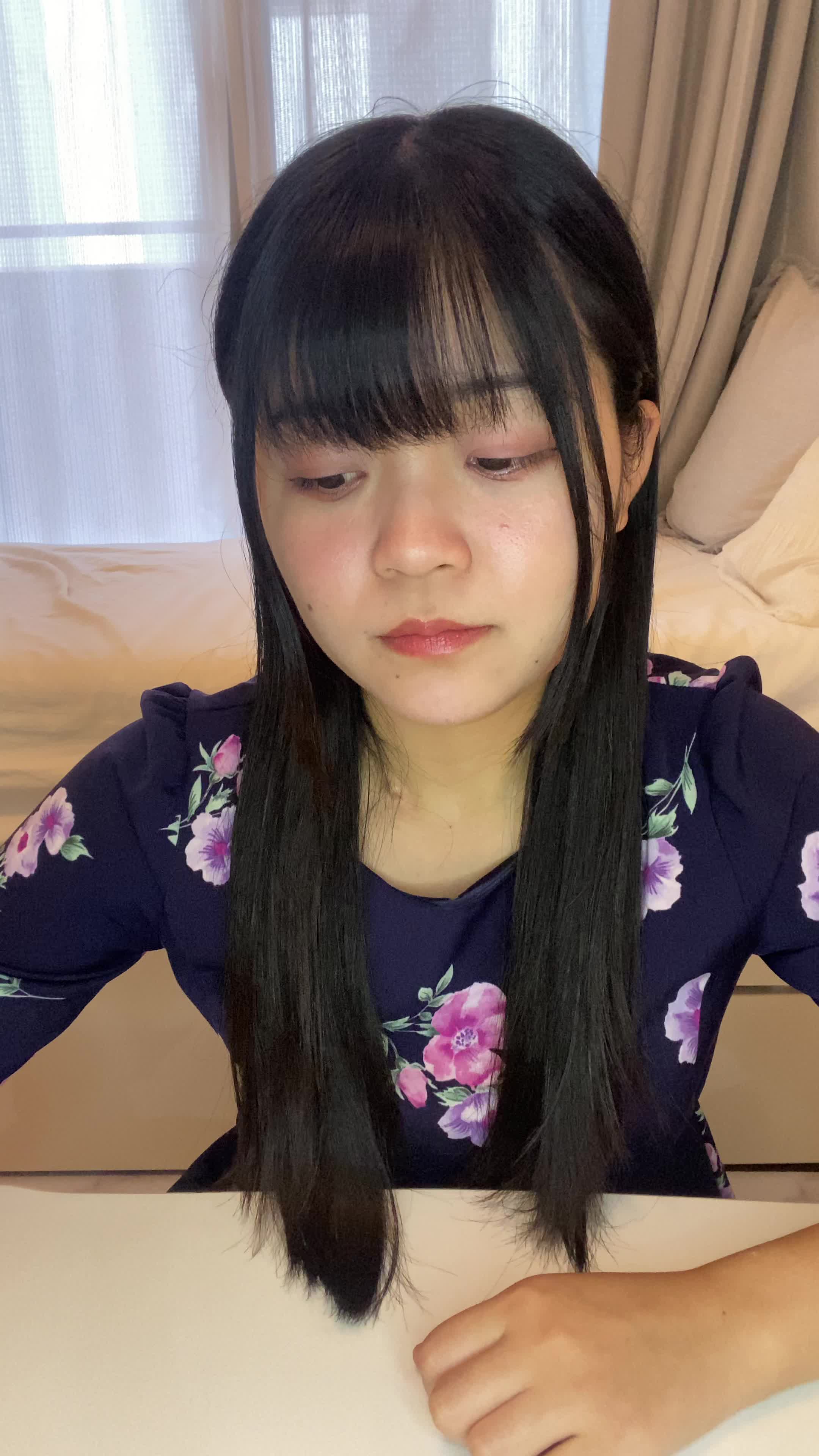 テーブルでカップを手に取り、「矯正中でも食べやすいメニュー」を考える表情