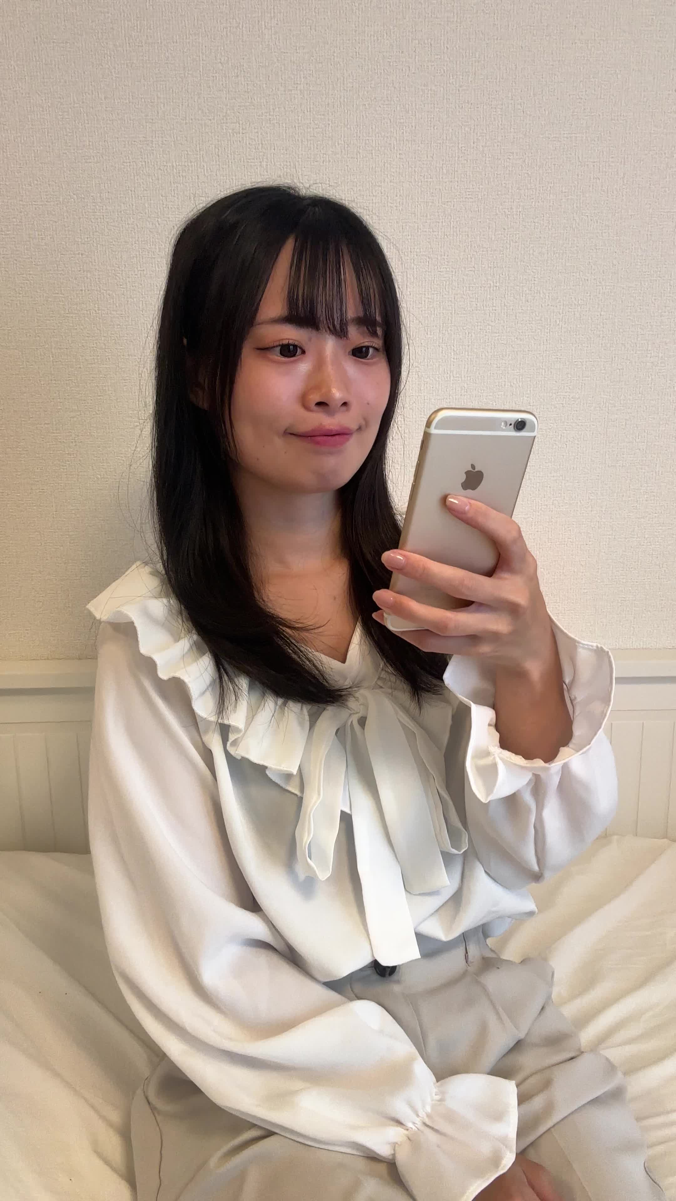 ソファでスマホを操作しながら、「次の休憩時間までに何を観るか選ぼう」と考える様子