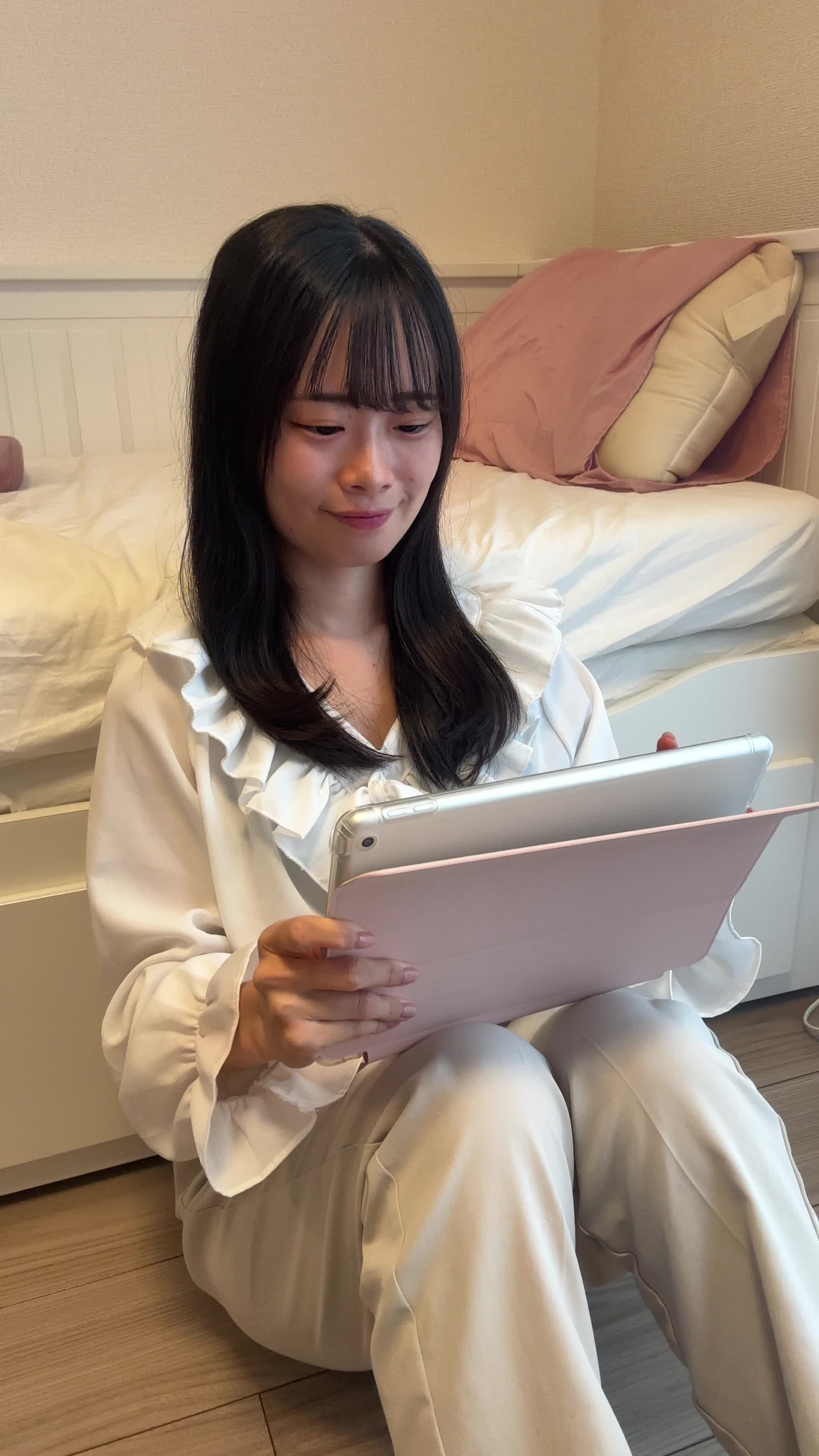 床で、「おすすめの映画がこんなにたくさん！」とスクロールする様子