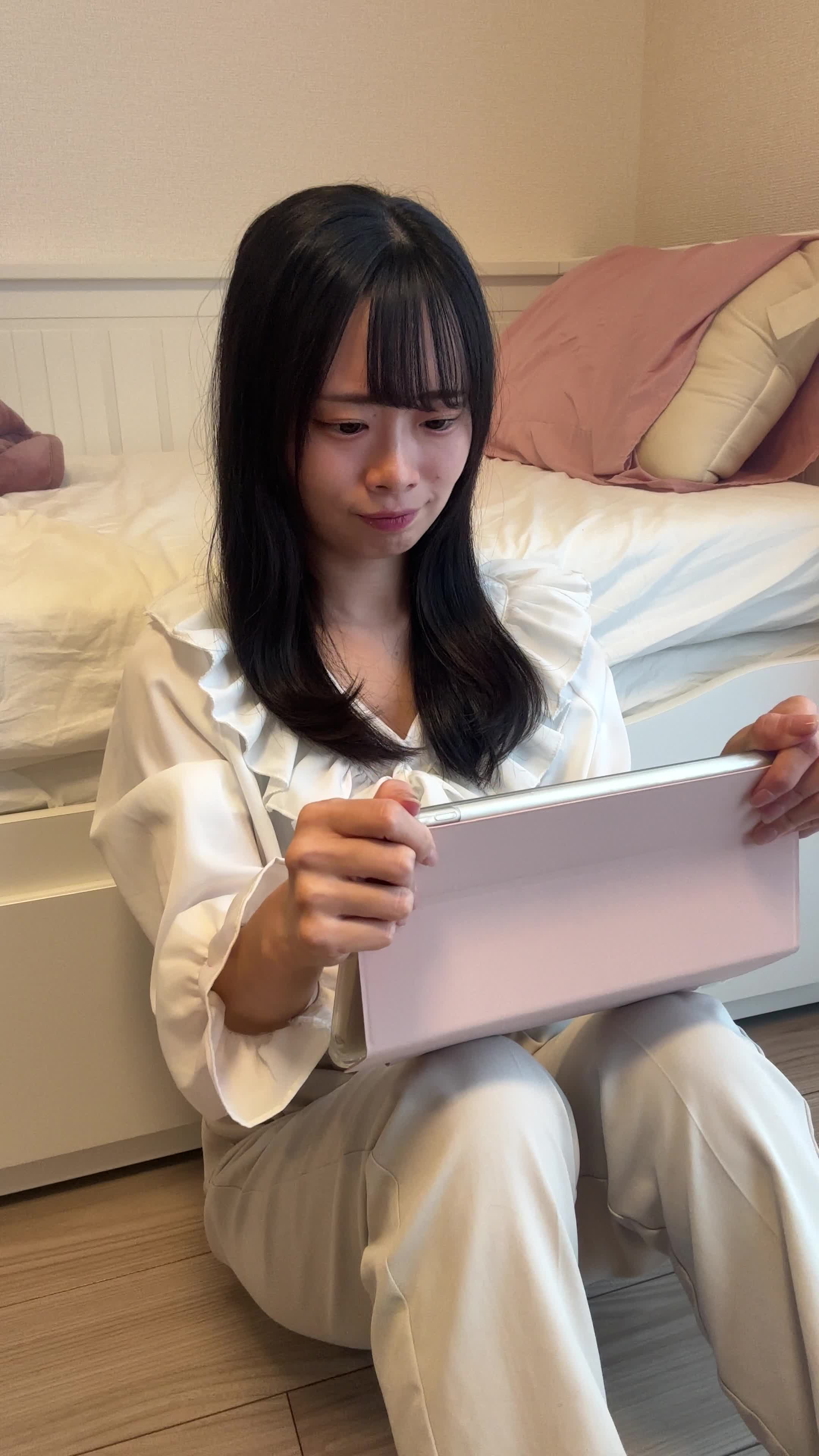 床でタブレットを手に、「このドラマ、続きが気になりすぎる」と頷く様子