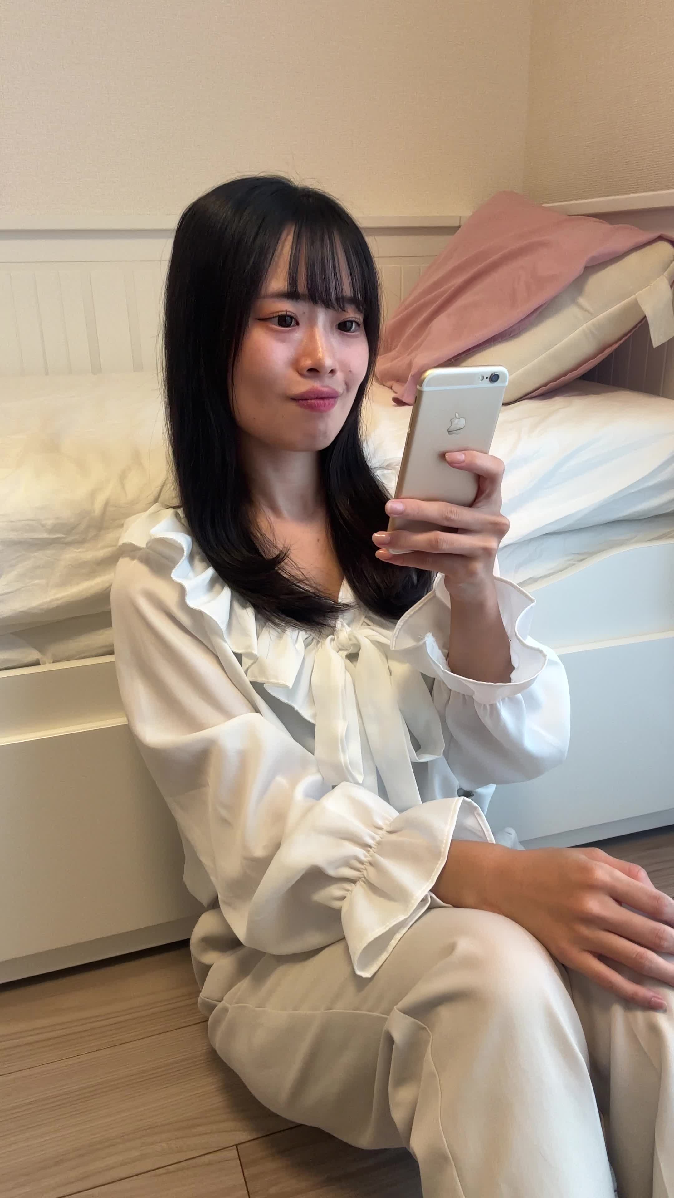 床に座り込み、スマホを手に「やっと終わった…」とホッとする表情