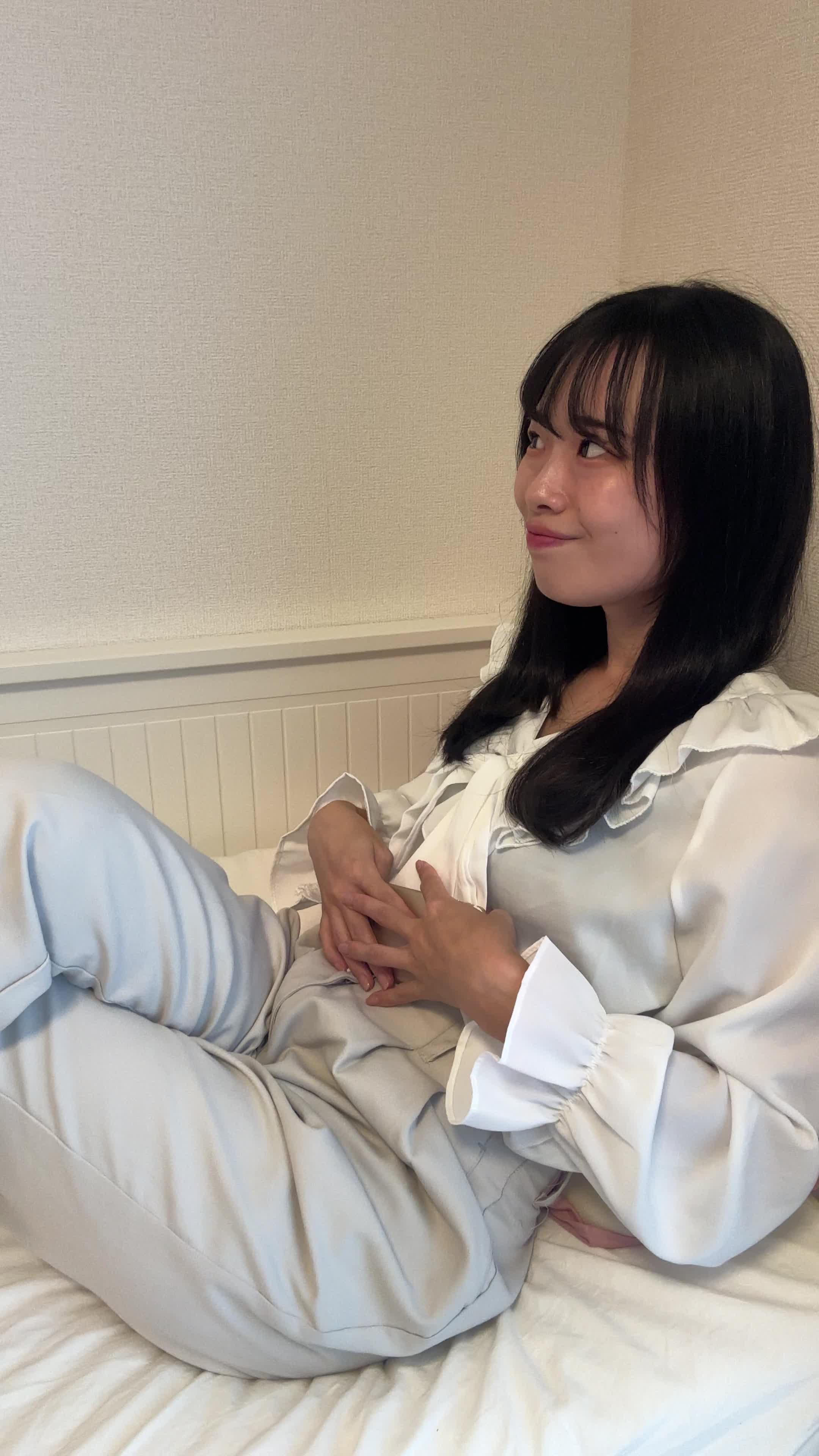 ベッドで脚を組みながら、「夜更かしする価値があるな」とニヤける動作