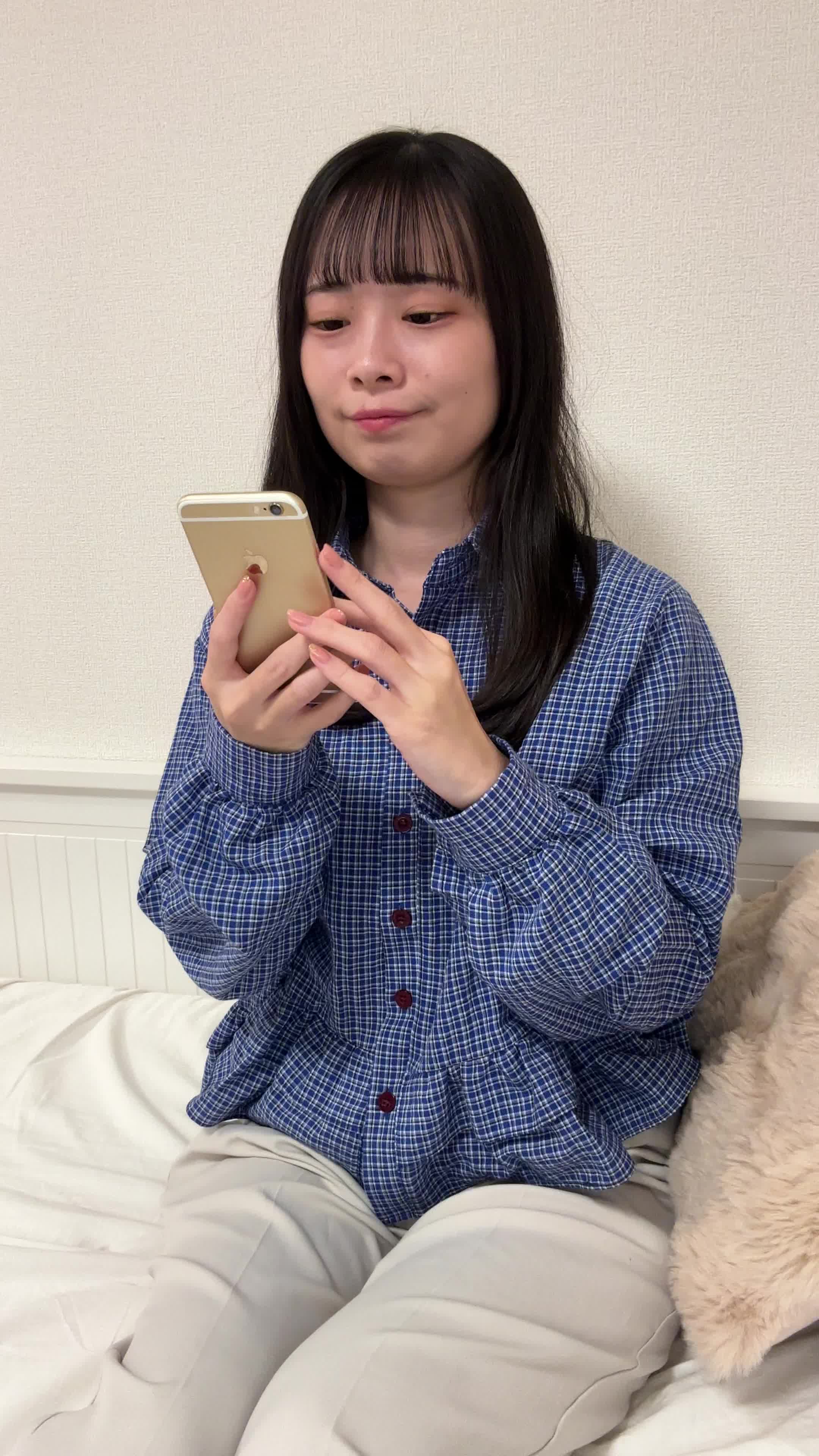 ソファでスマホを見ながら、「矯正の口コミ」を調べて頷く様子