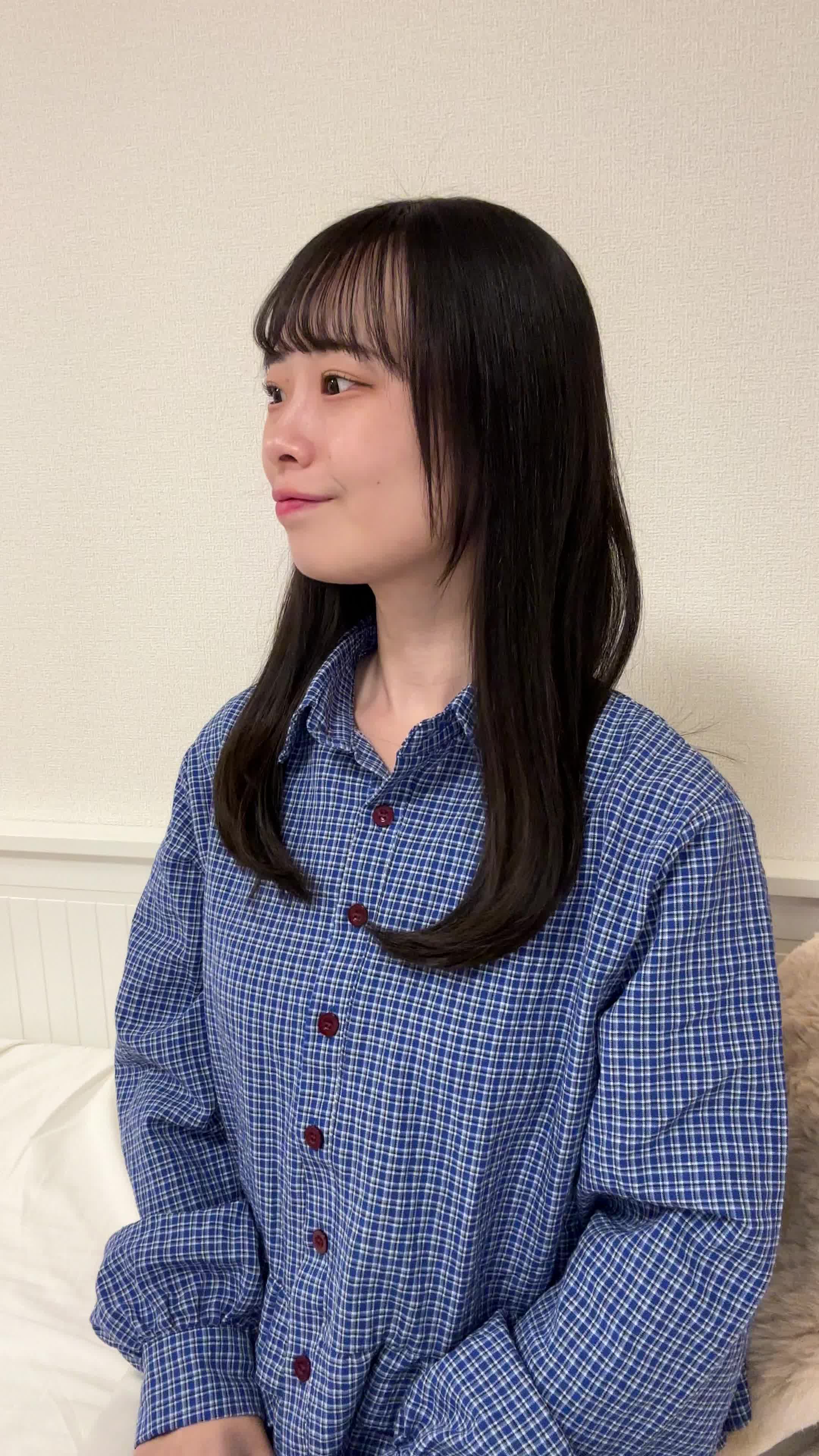 ソファで友達と話しながら、「自分の歯並びが気になる」と口元を隠す仕草