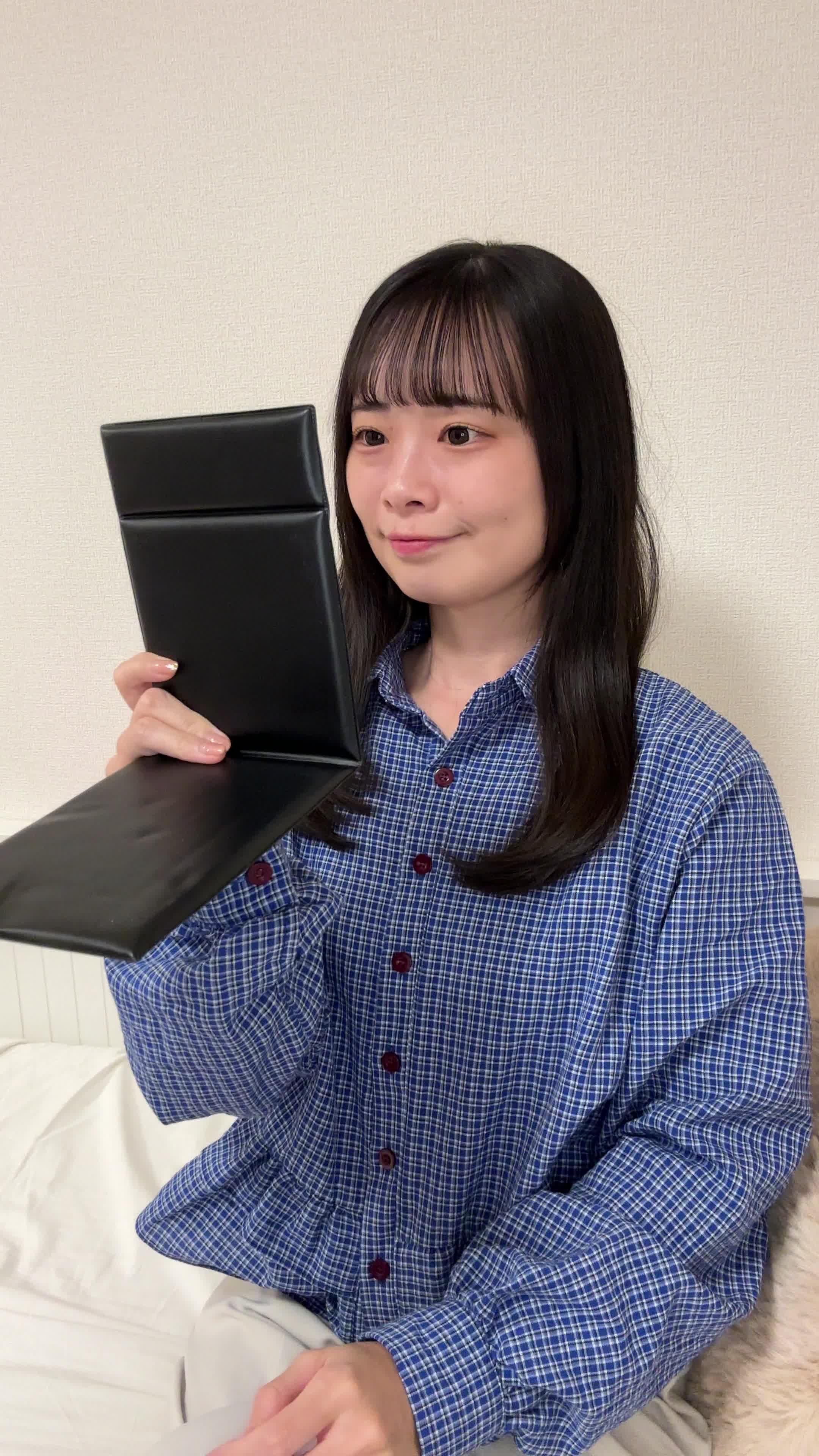 ソファで鏡を見ながら、「矯正後の自分を想像して」期待に胸を膨らませる姿