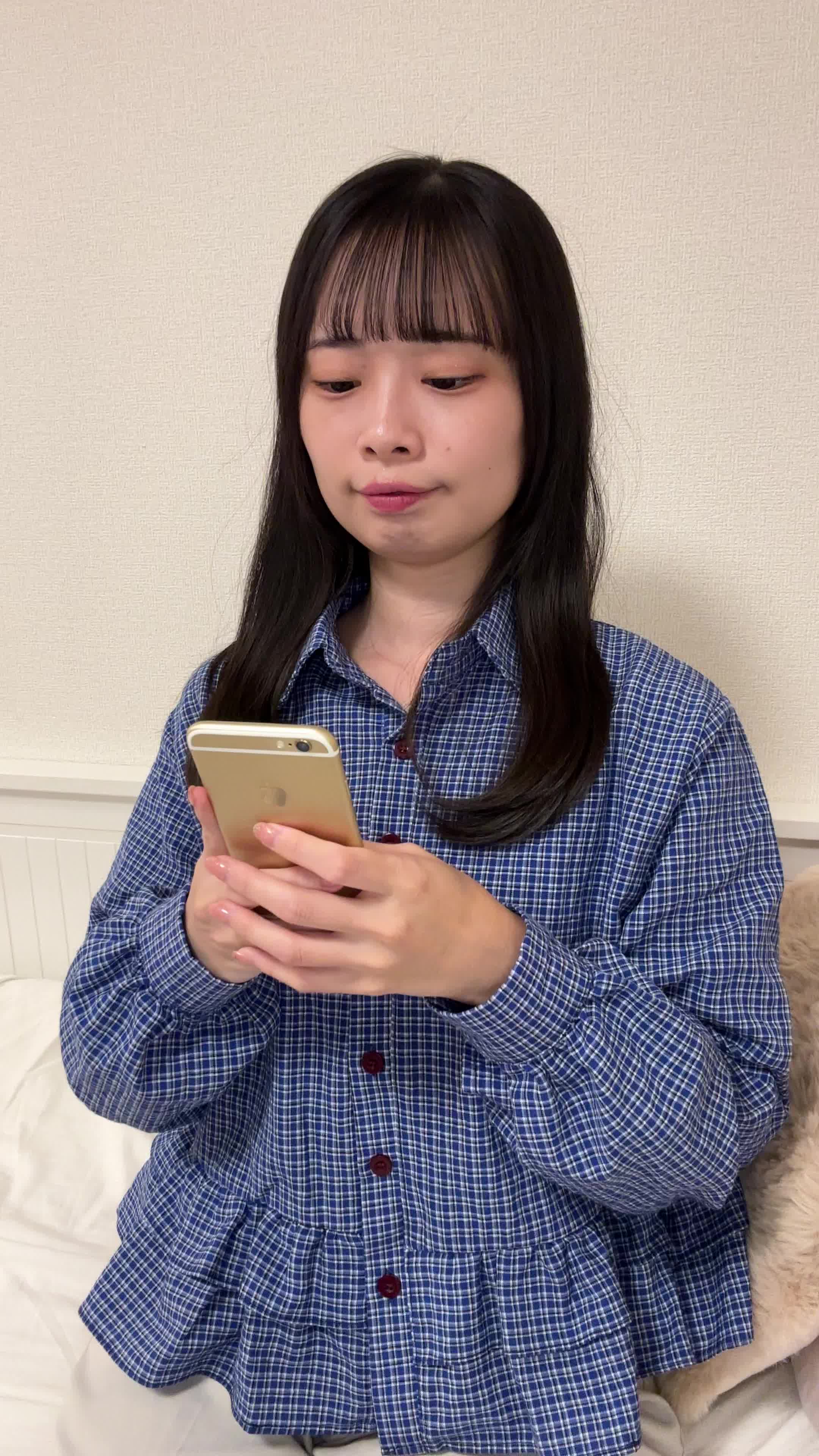 ソファでスマホを置き、「矯正を始める決意を固める」前向きな表情