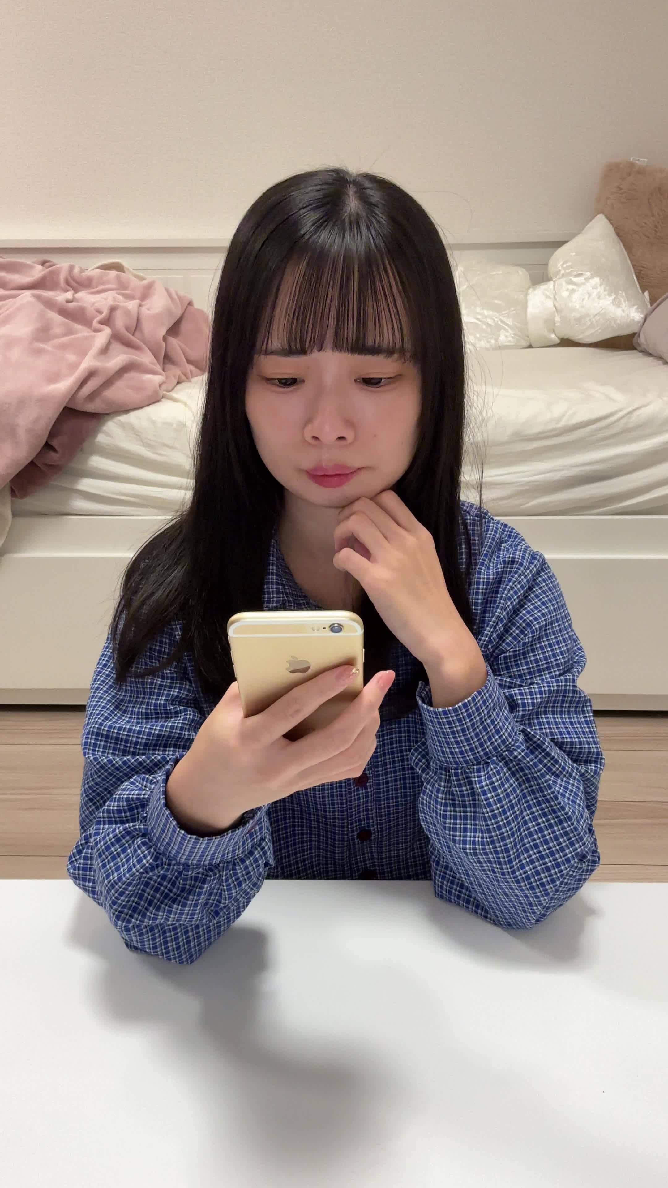 テーブルでスマホに検索結果をスクロールしながら、「どの矯正方法がいいのかな？」と考える仕草