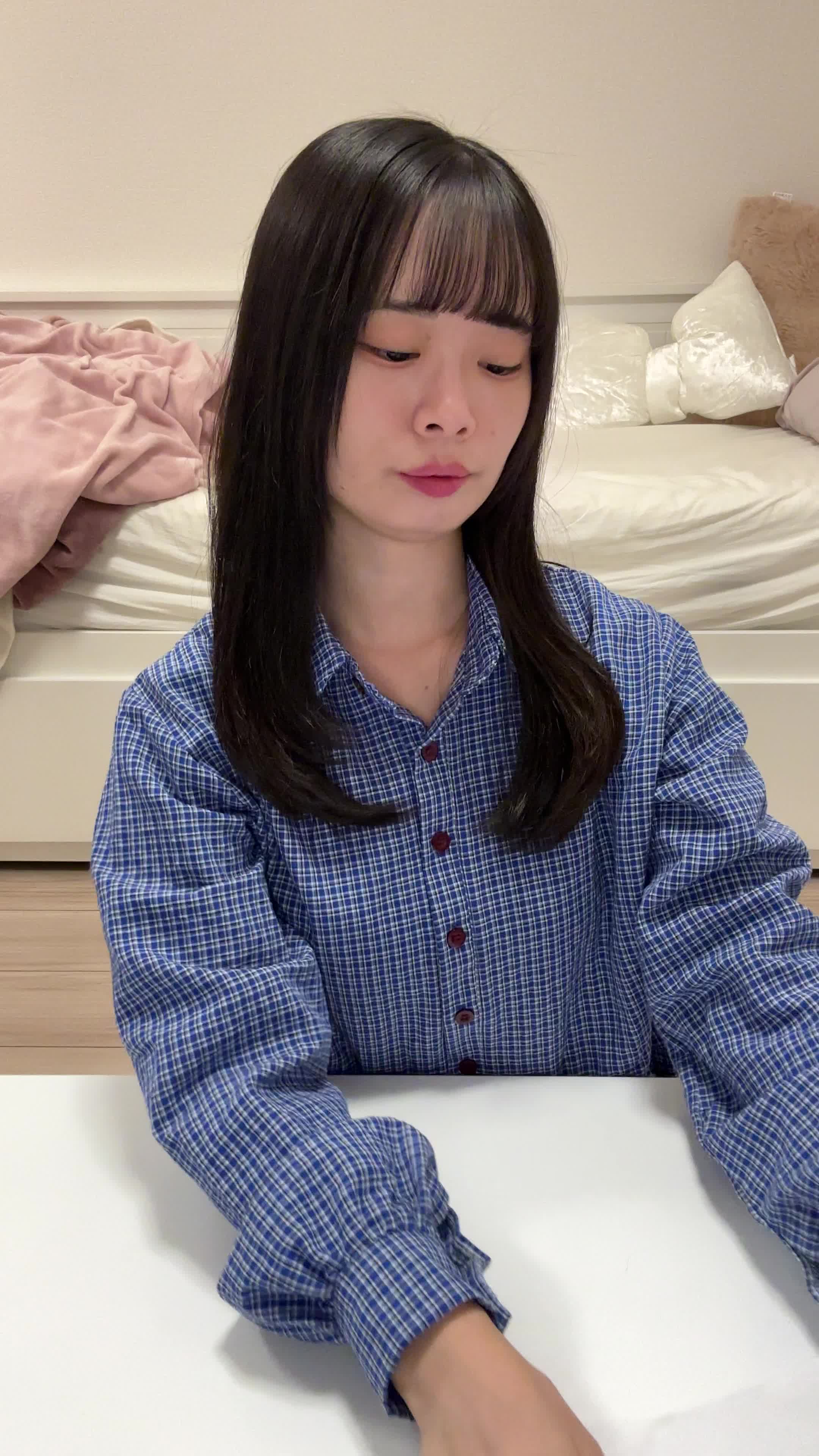 テーブルで矯正治療のカタログを見ながら、「これなら目立たないかも」と安心する表情