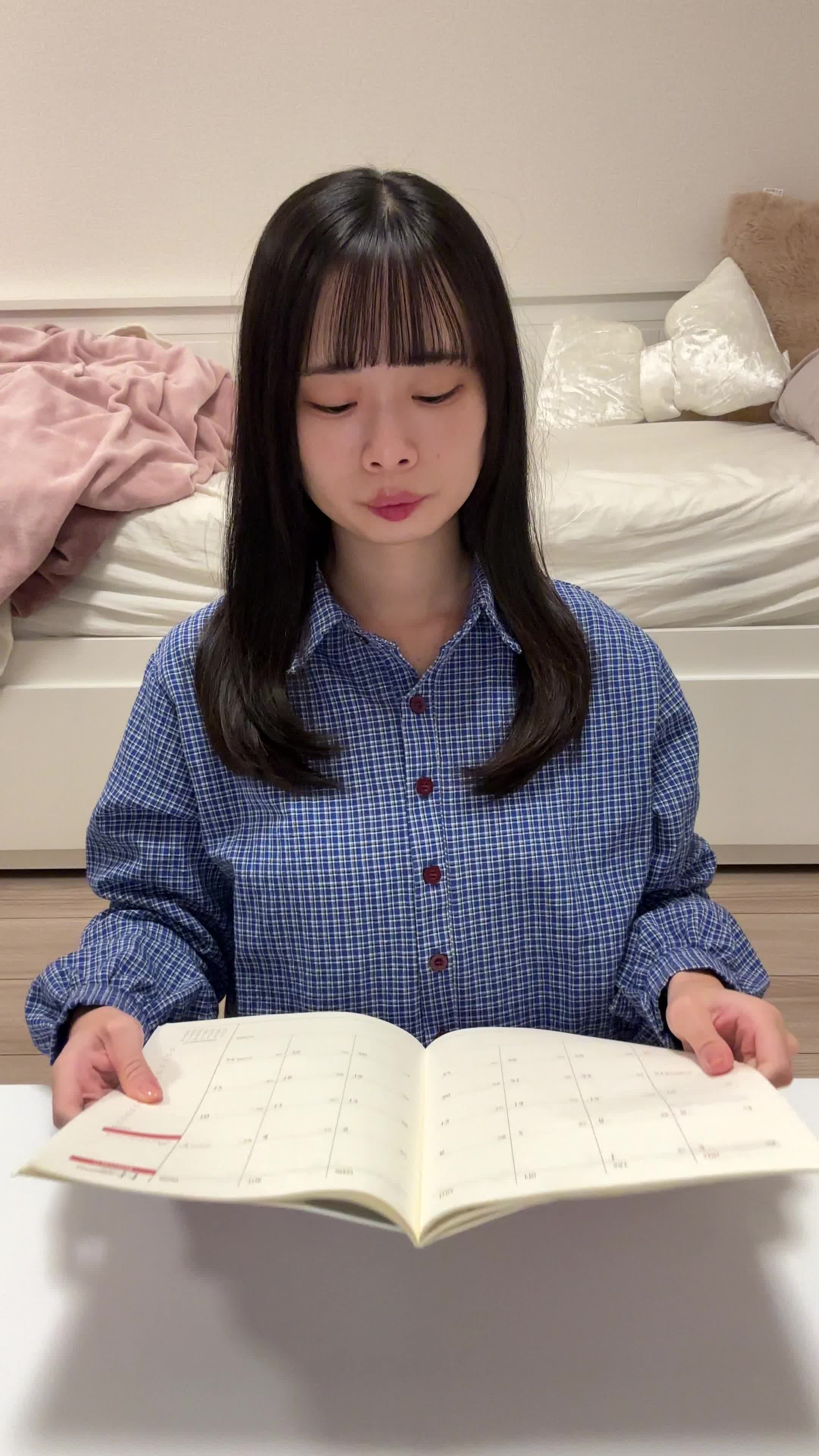 テーブルに手帳を開き、「治療の予約日を確認する」真剣な様子