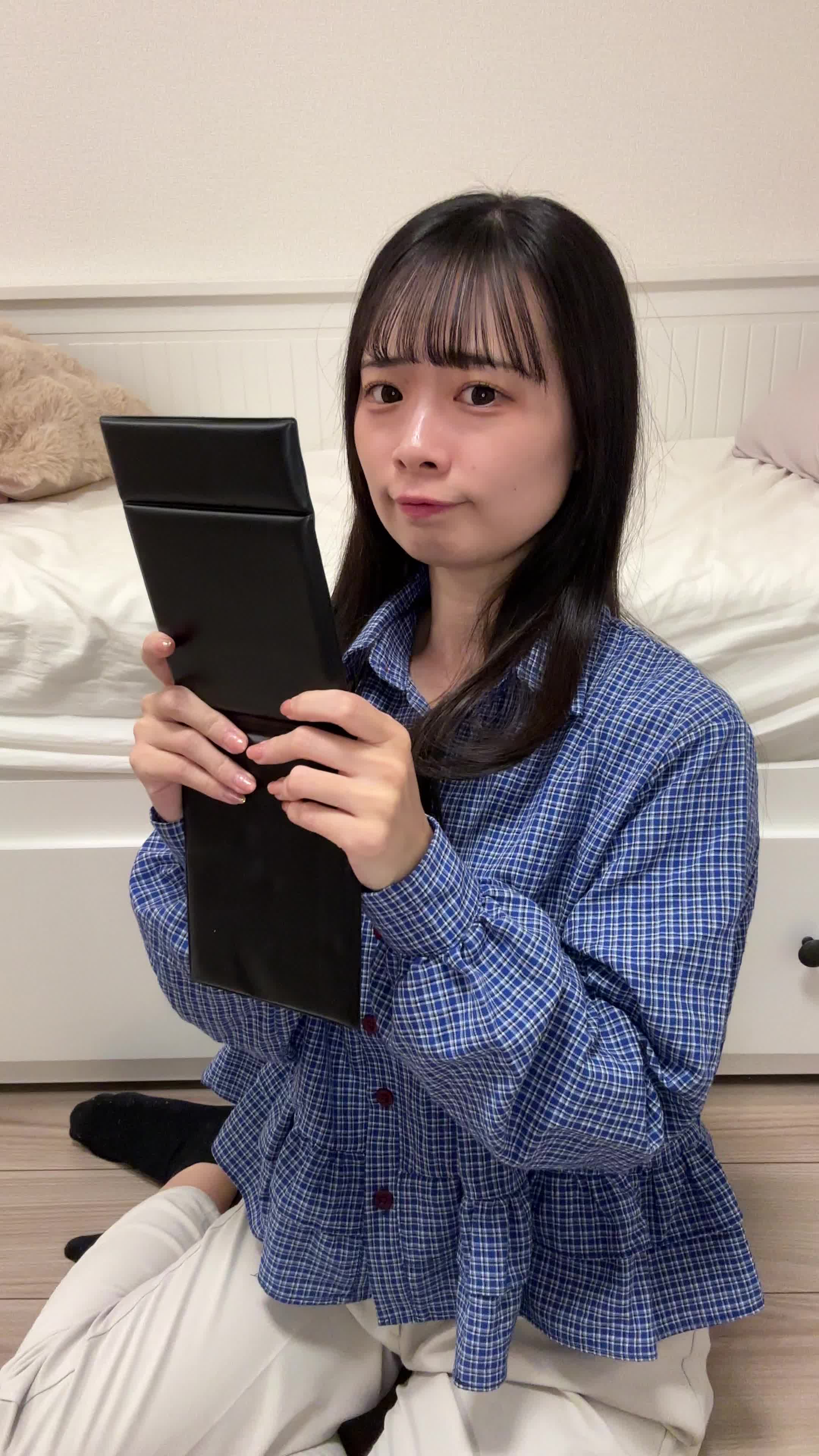 床で鏡を見つめ、「矯正器具を目立たせない工夫」を考える姿