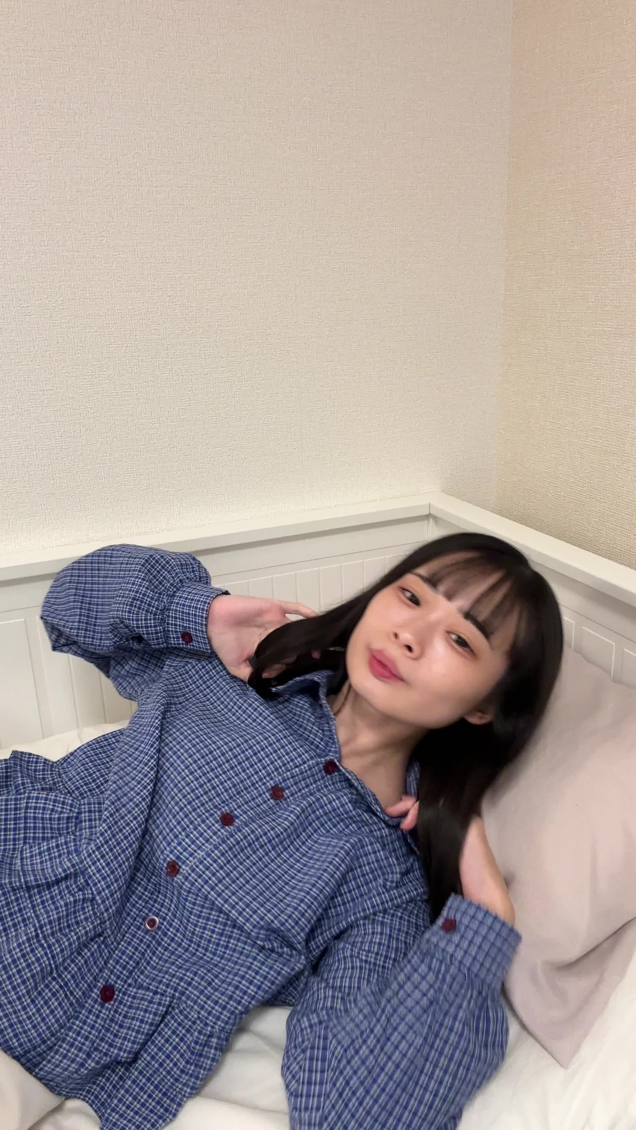 ベッドで横になり、「笑顔がもっと綺麗になるのかな？」と微笑む様子