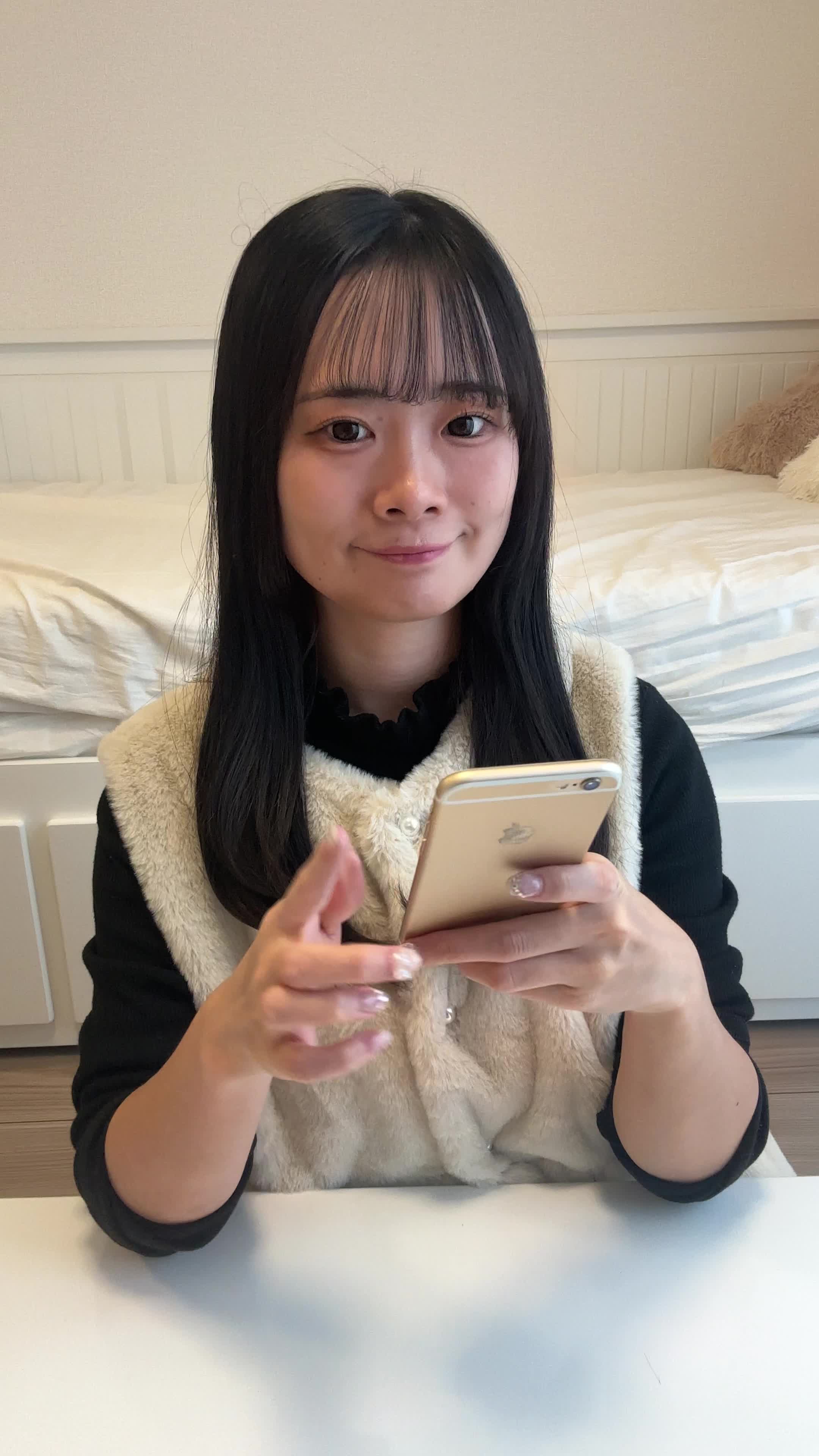 椅子に浅く腰掛け、「クーポンを適用してさらにお得に」とスマホを操作する姿