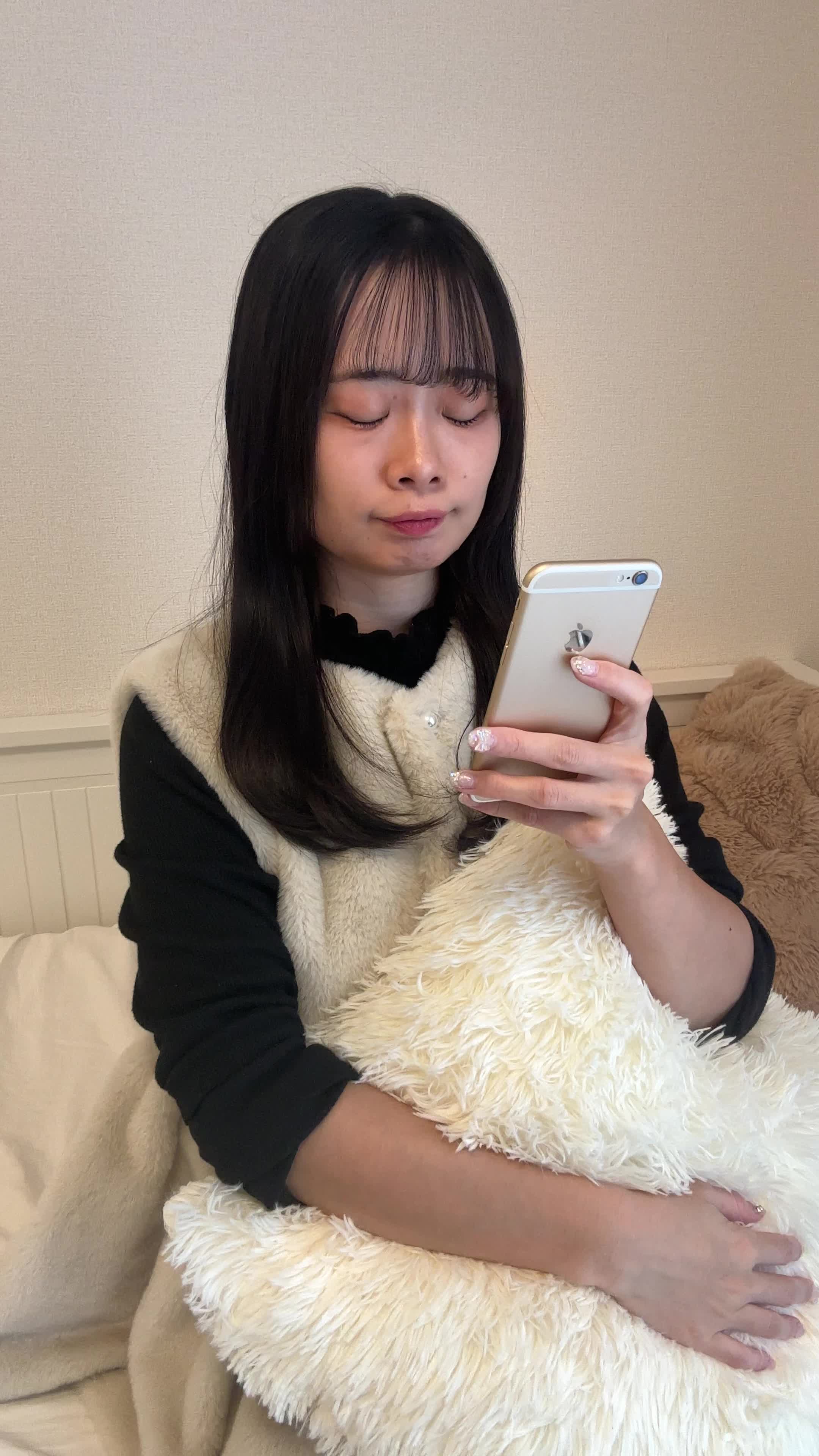 ソファでクッションを抱え、スマホの画面を見て「これがタイムセール価格？」と驚く様子