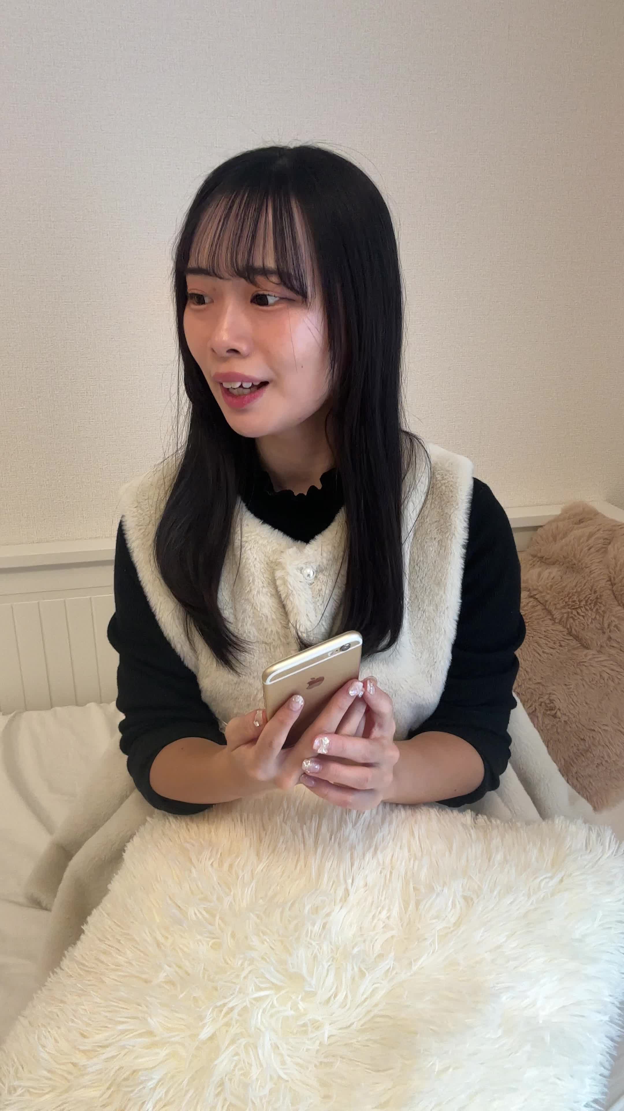 ソファでスマホを見ながら、「友達におすすめアイテムを共有する」楽しそうな表情