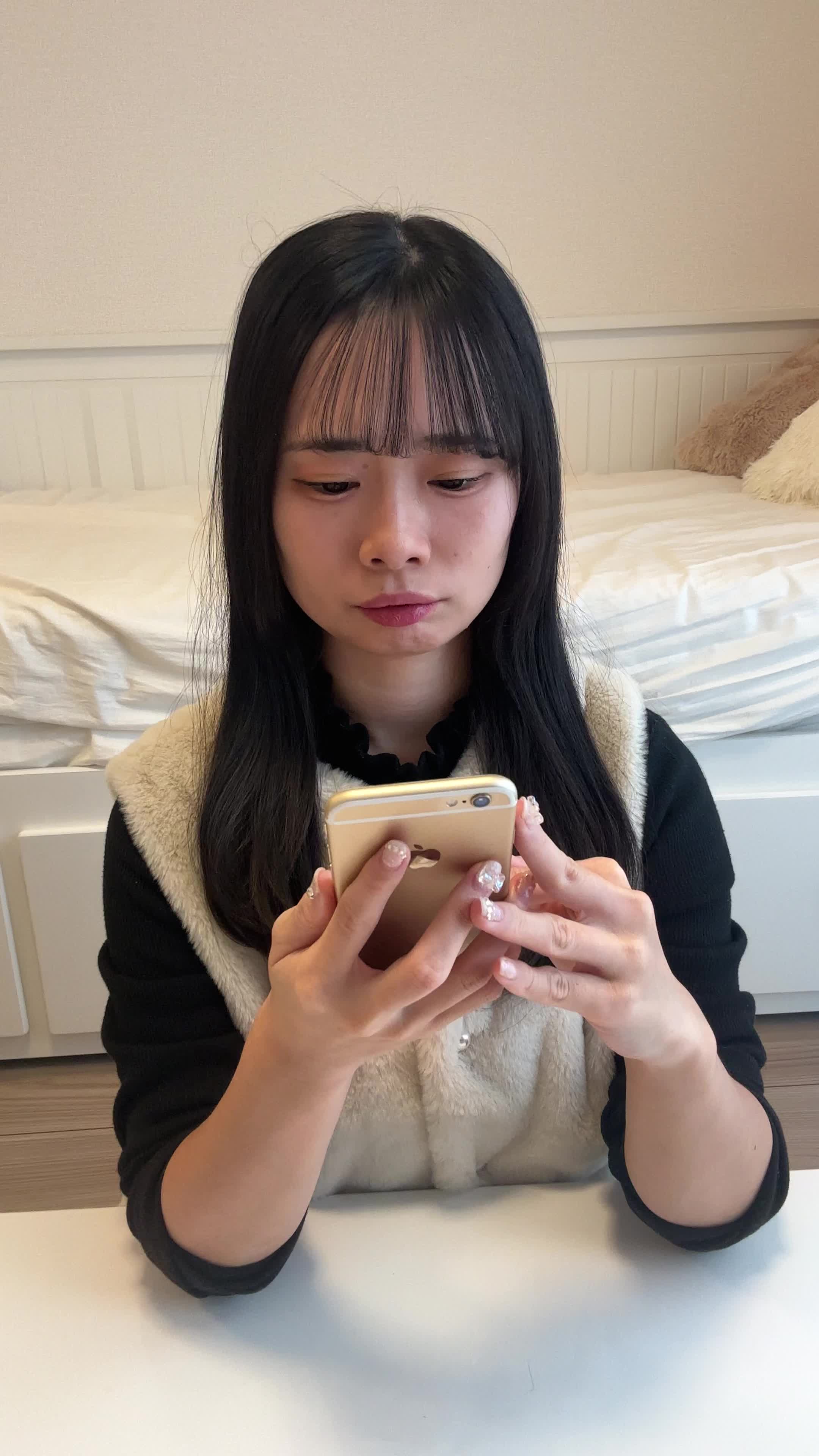 テーブルでスマホを操作しながら、「レビューを読んで納得する」真剣な表情