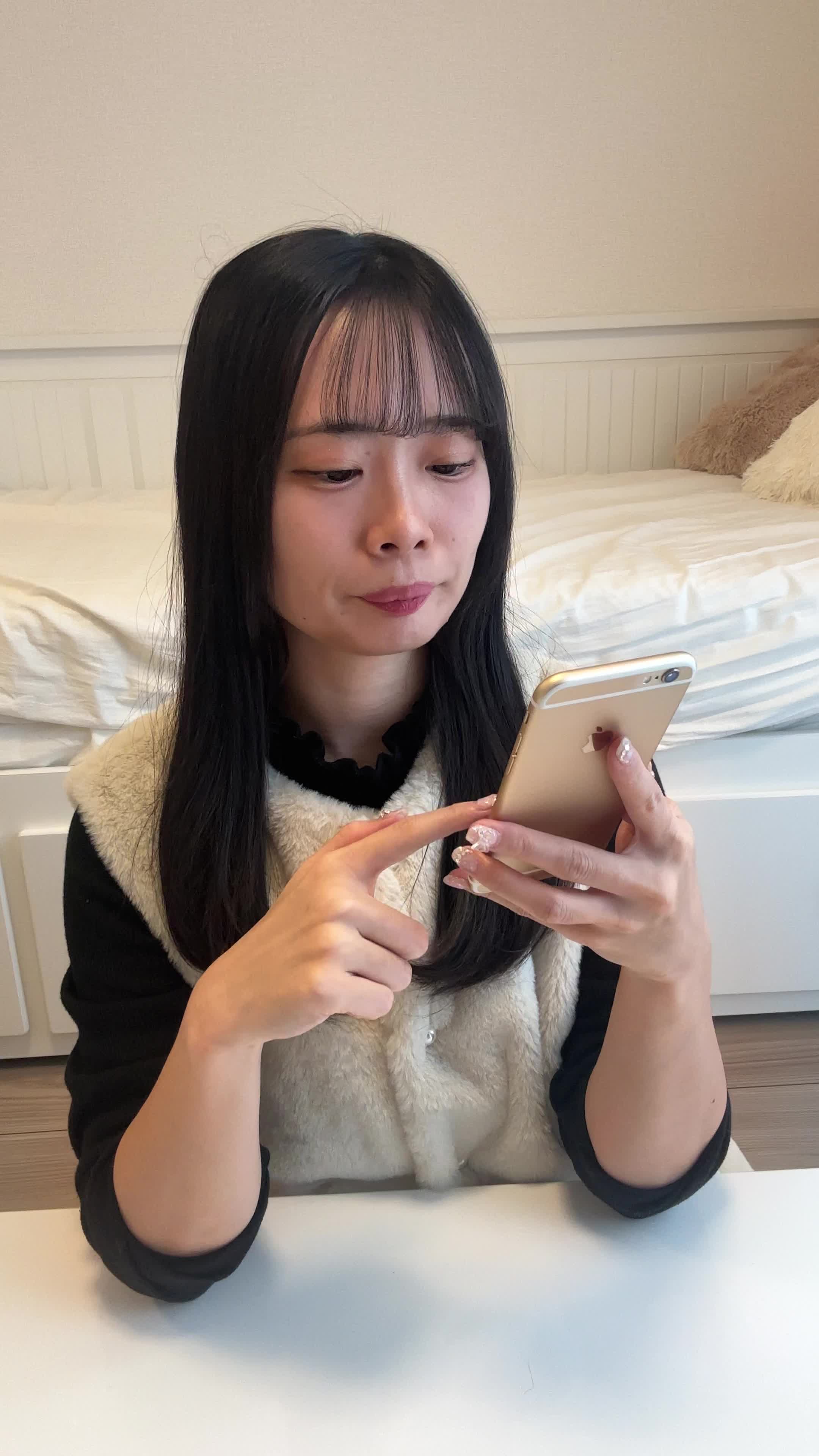 テーブルでスマホを操作し、「注文履歴を見て再注文を考える」真剣な表情