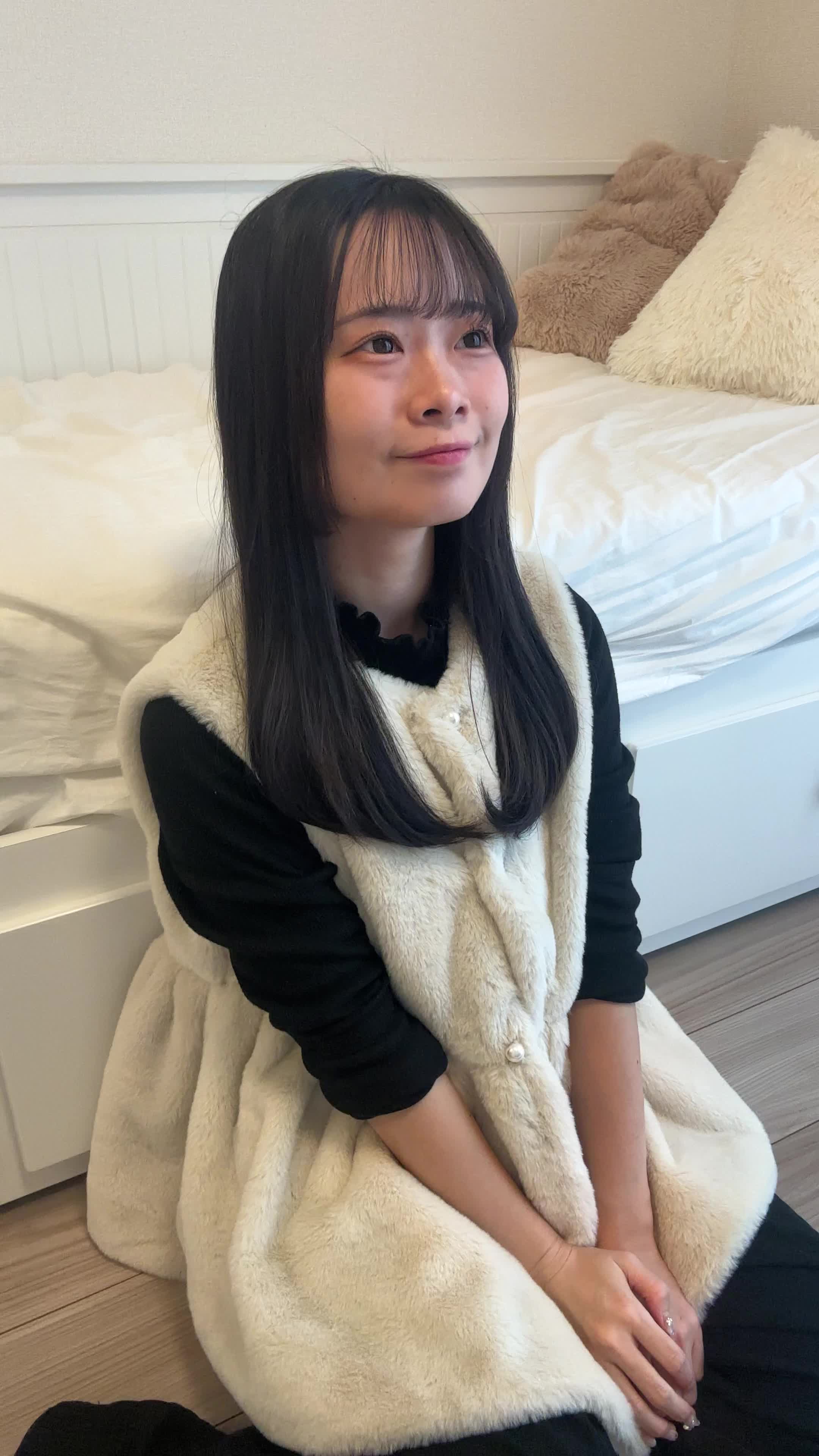 床で膝を崩して座り、「新しいアイテムの到着を待ちながらワクワクする」仕草