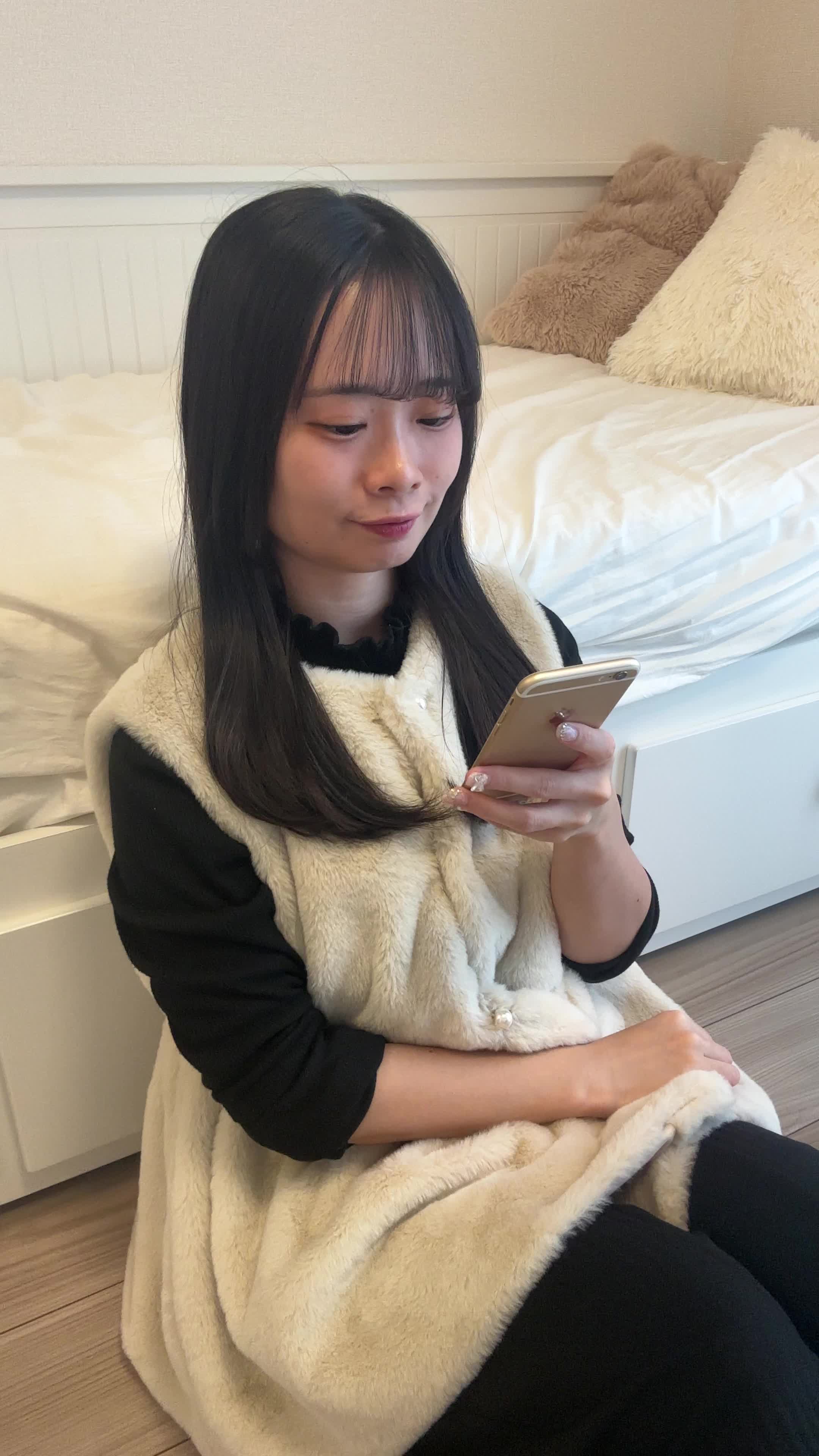 床に座り、「注文完了画面を見て達成感を感じる」笑顔を浮かべる様子