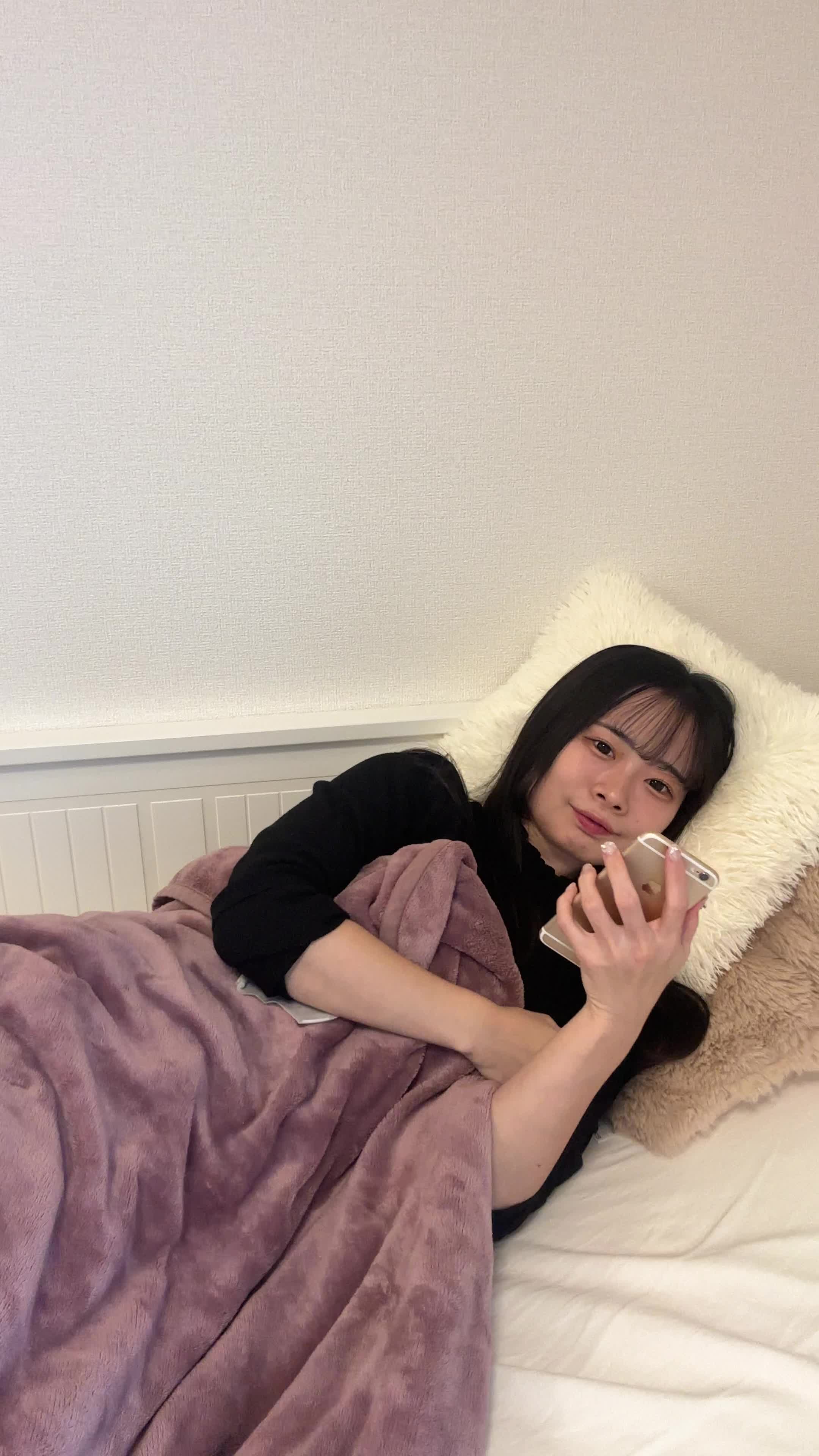 ベッドで横になり、「夜中に気になる商品を検索してしまう」楽しそうな表情