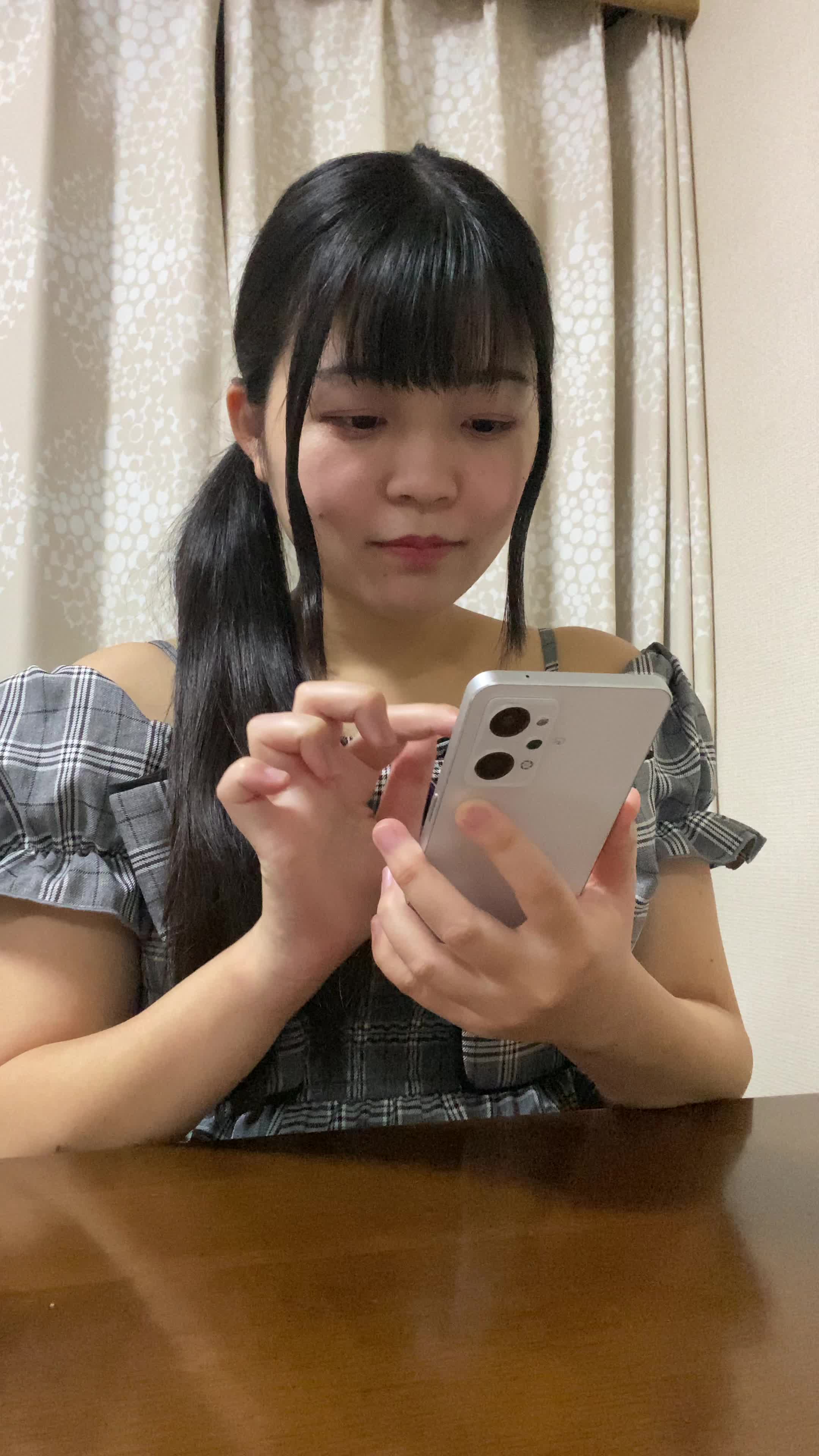 椅子に浅く腰掛け、「クーポンを適用してさらにお得に」とスマホを操作する姿