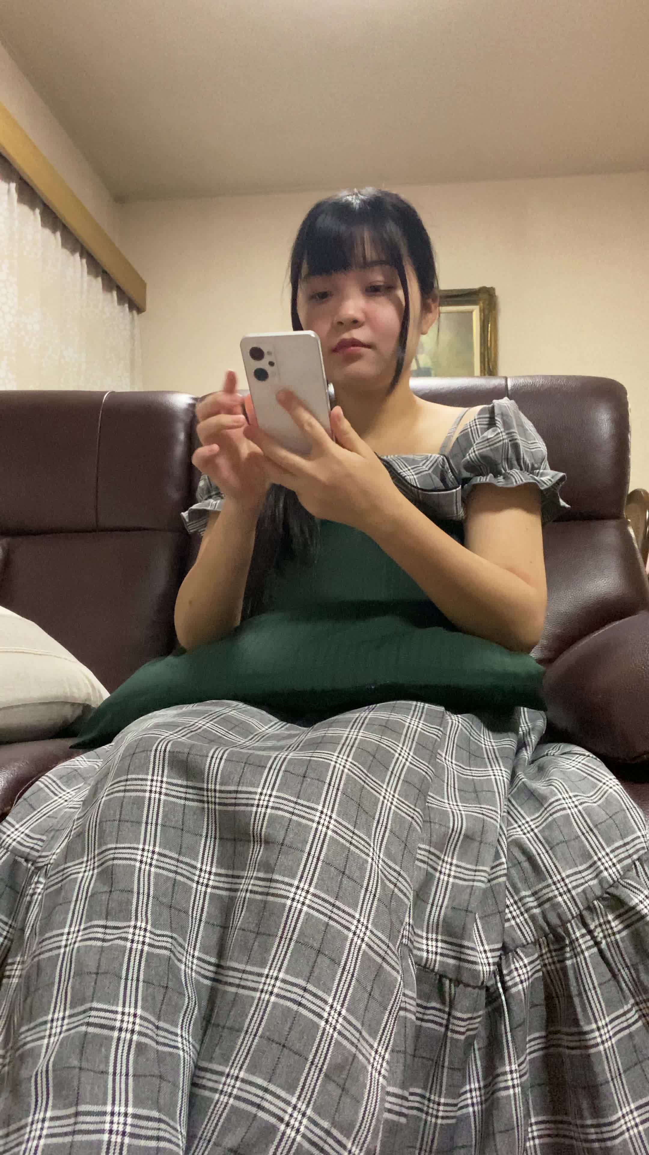 ソファでクッションを抱え、スマホの画面を見て「これがタイムセール価格？」と驚く様子