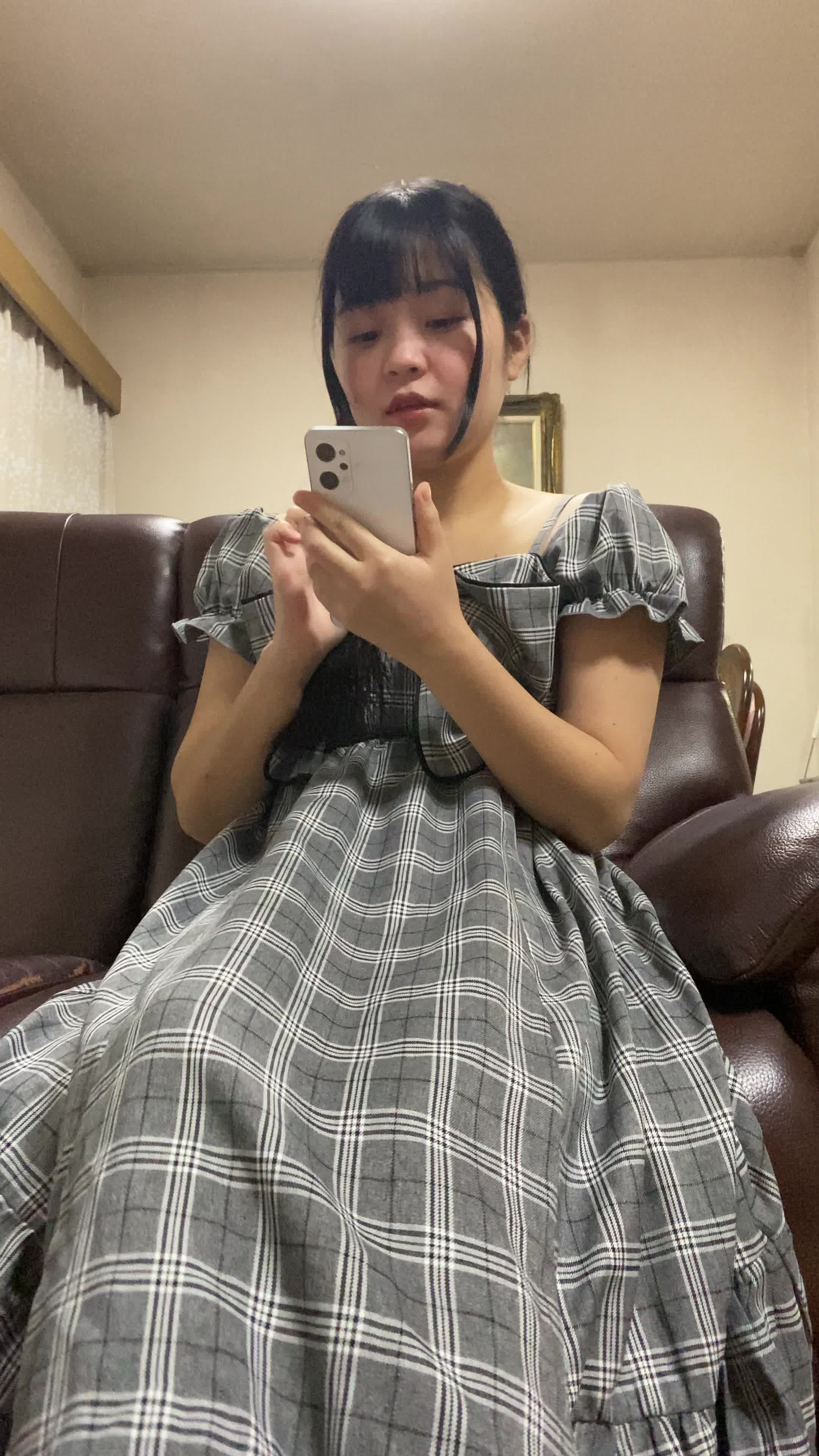 ソファで友達と話しながら、「これが新作だよね！」と嬉しそうに見せる姿