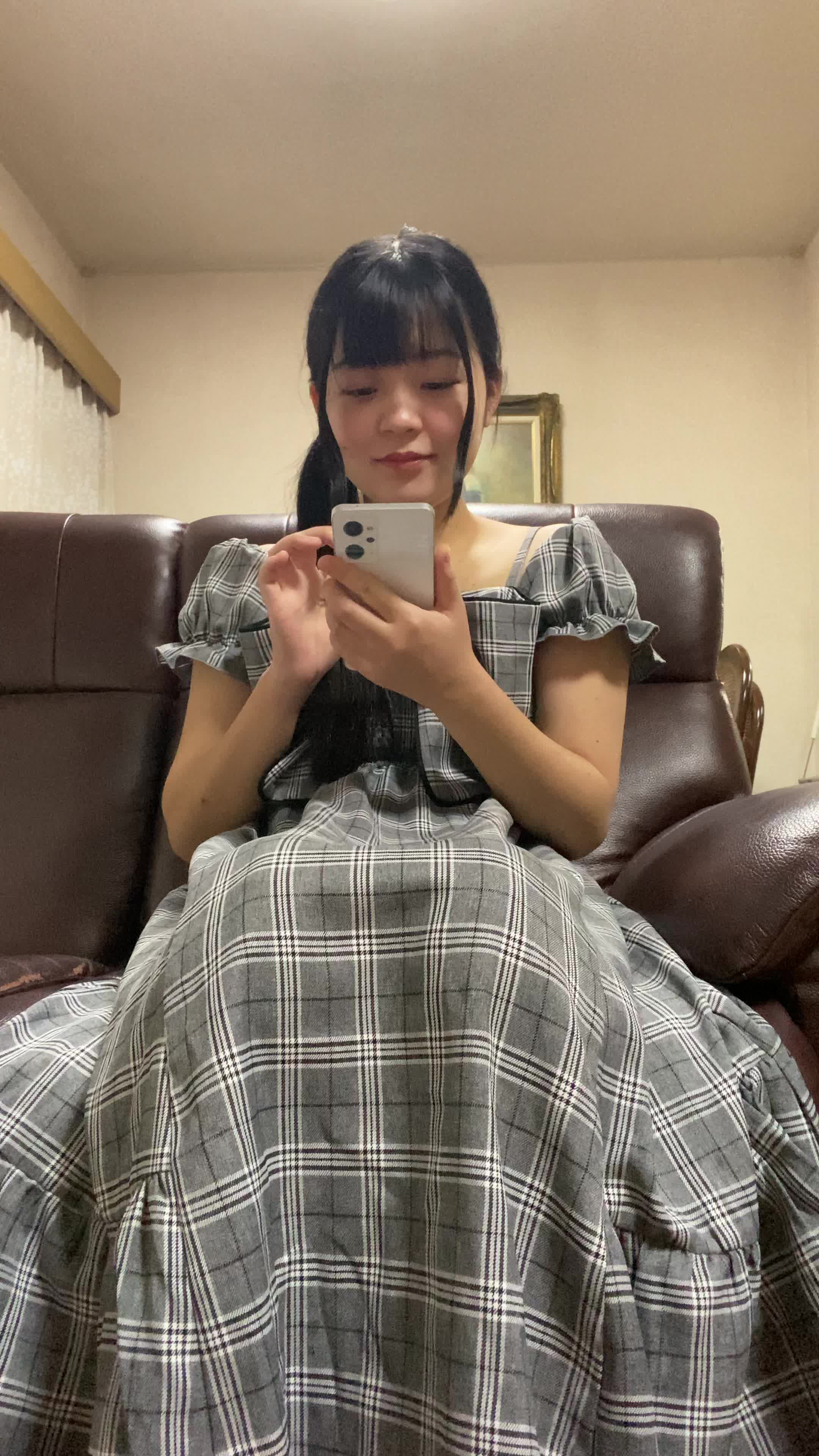 ソファでスマホを見ながら、「友達におすすめアイテムを共有する」楽しそうな表情