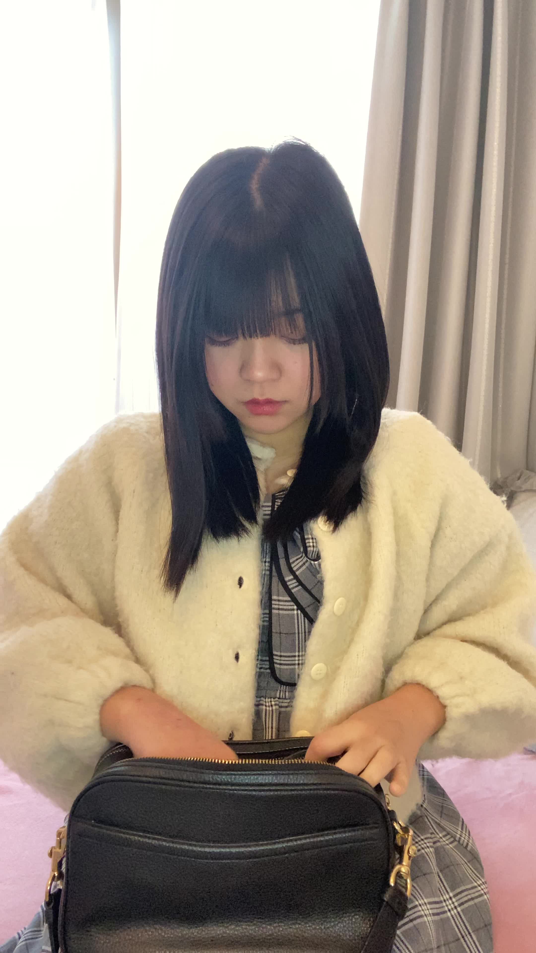 ソファでカバンの中を確認しながら、「体臭ケアスプレーを常備する」様子