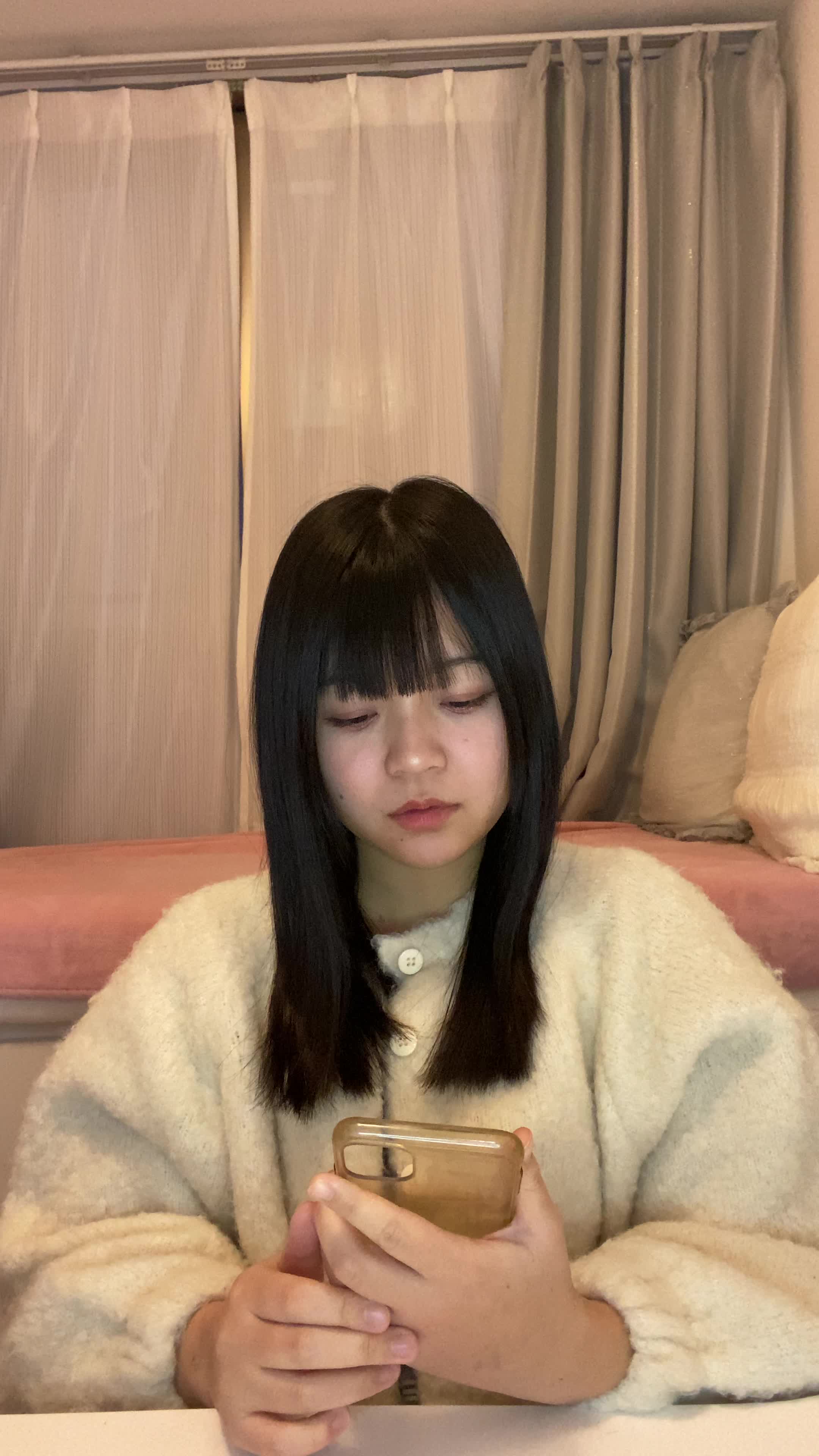 テーブルに置いたスマホを見ながら、「新しいケア方法を試す決意を固める」動作