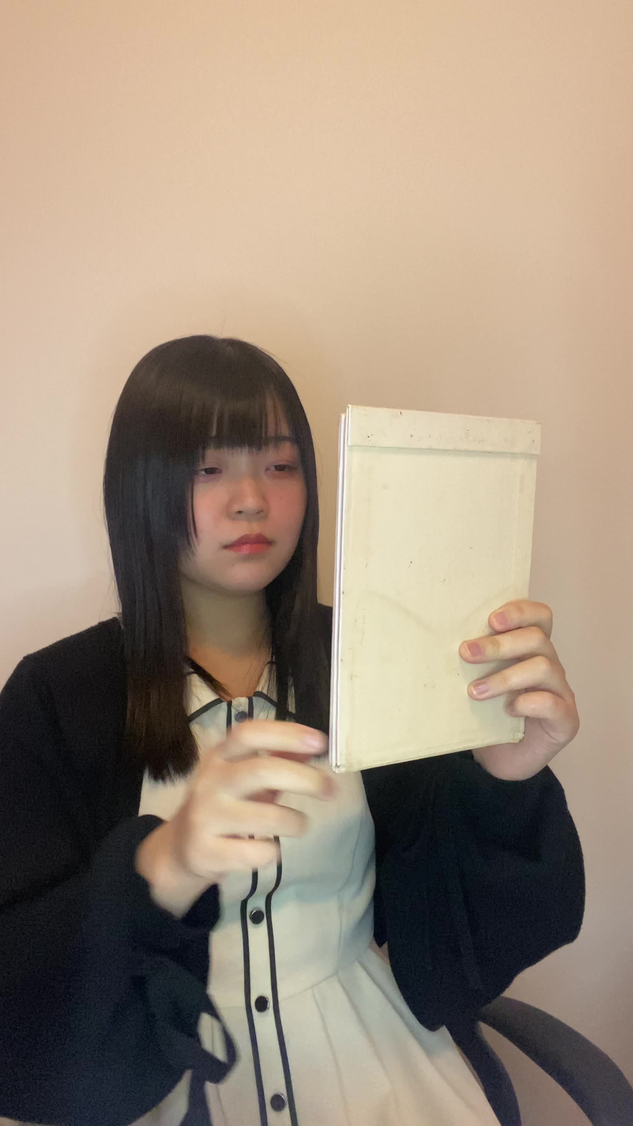 椅子に座り、鏡を見ながら白髪を気にして「どうにかならないかな」と悩む表情