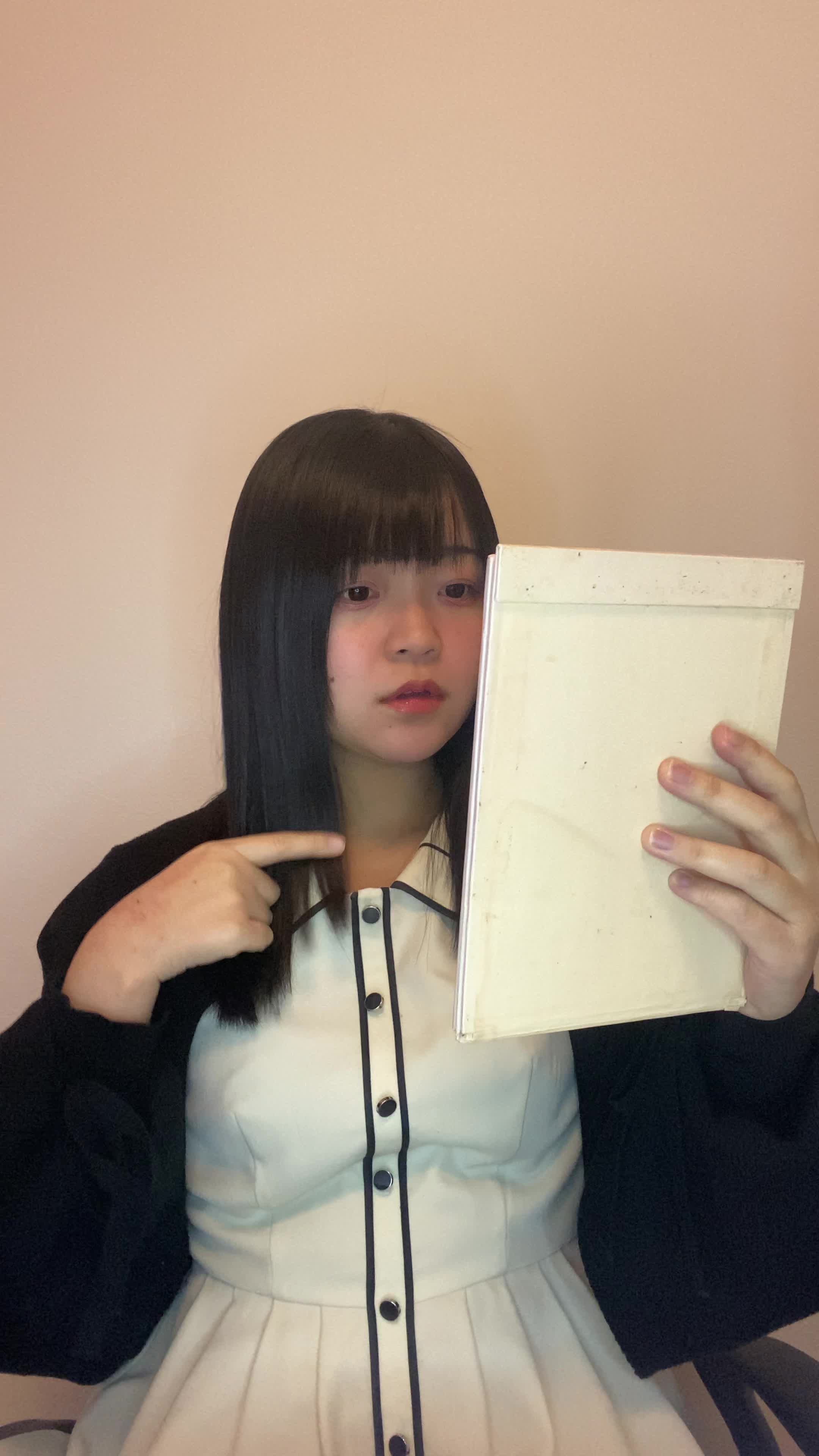 椅子に浅く腰掛け、鏡の前で「白髪部分を少し整える」動作