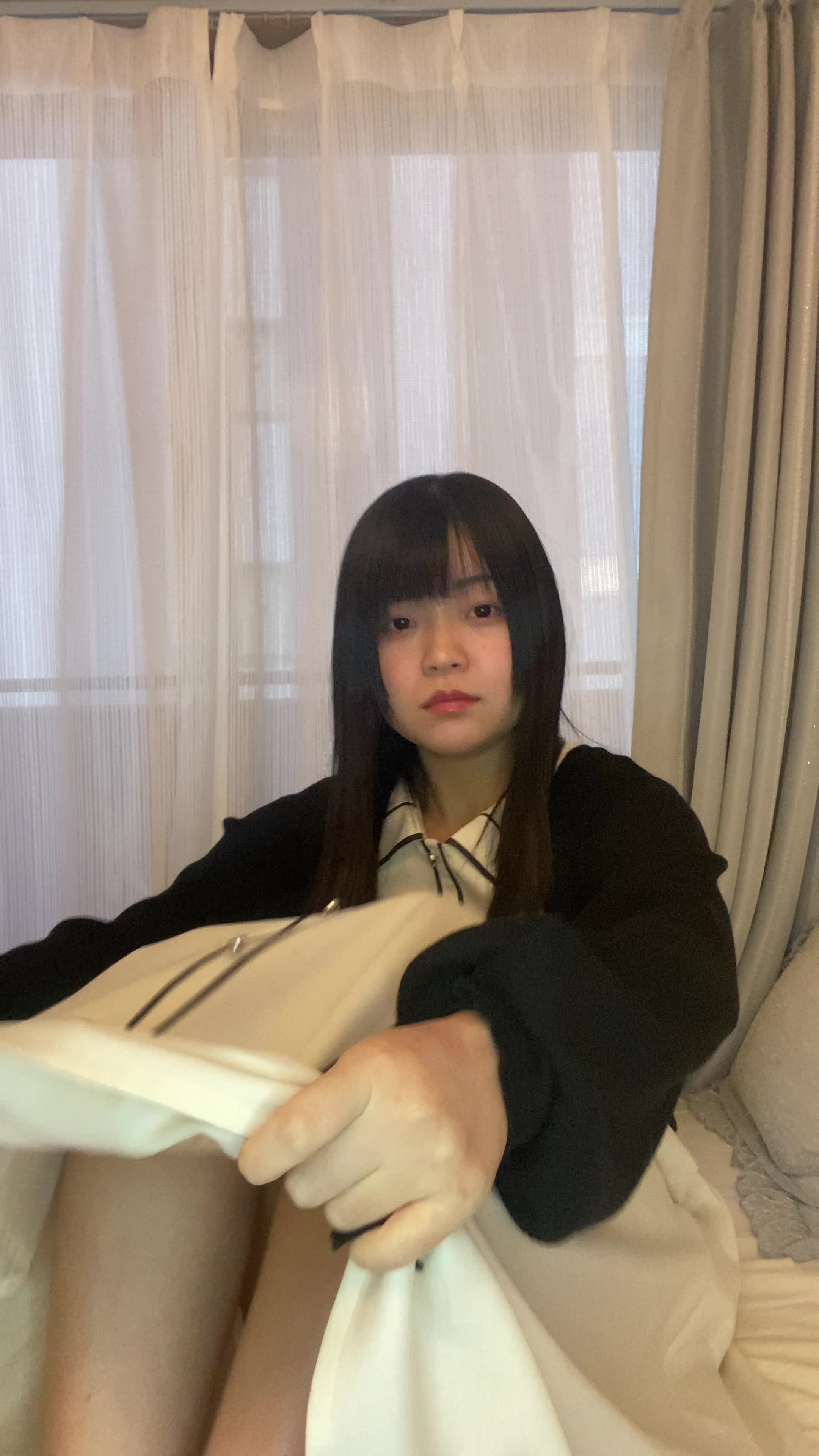 ソファで膝を抱え、「白髪が目立つのをどう隠すか考える」少し困った様子