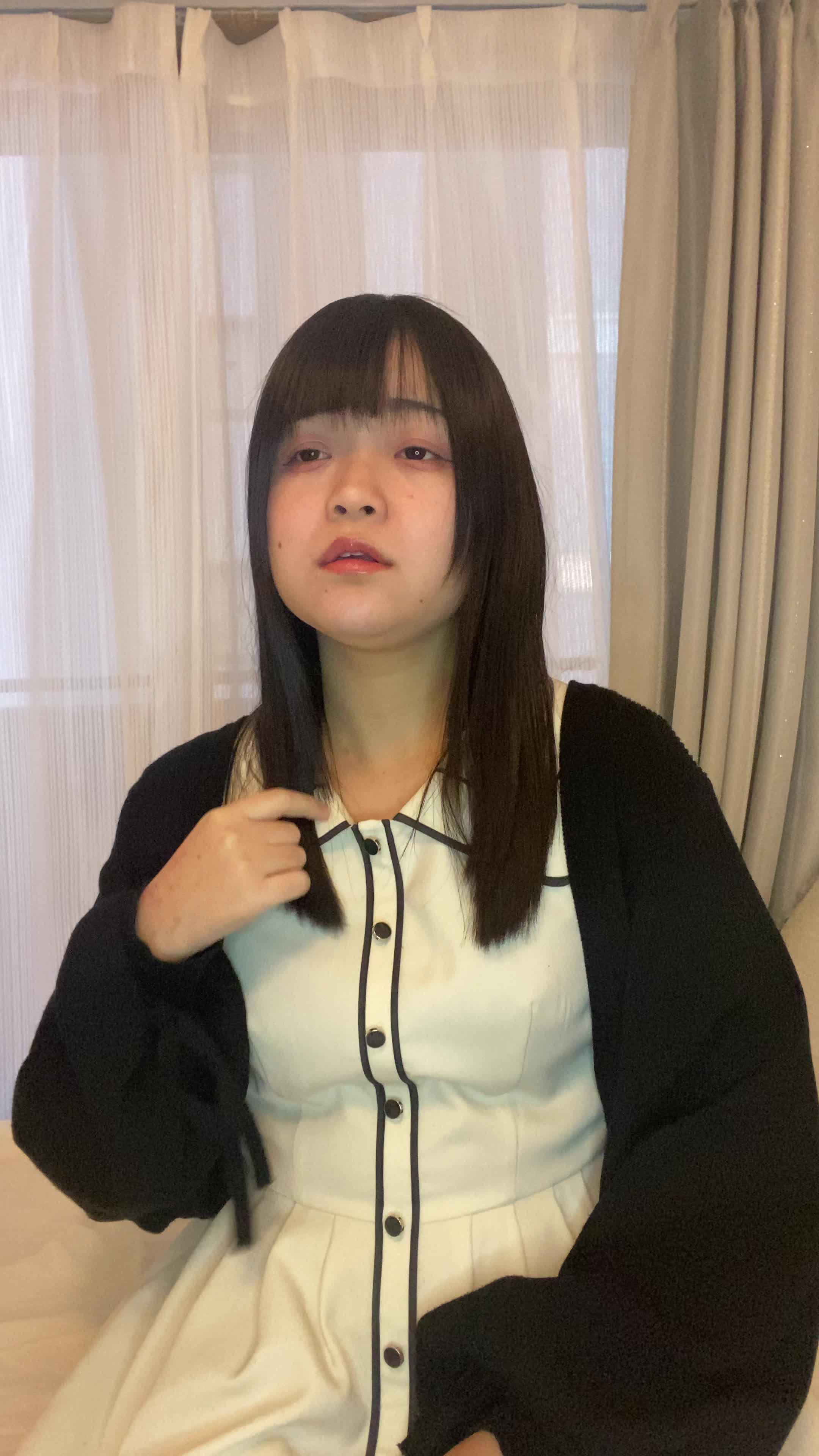 ソファで友達と話しながら、「白髪が気にならないヘアスタイルを聞いている」姿