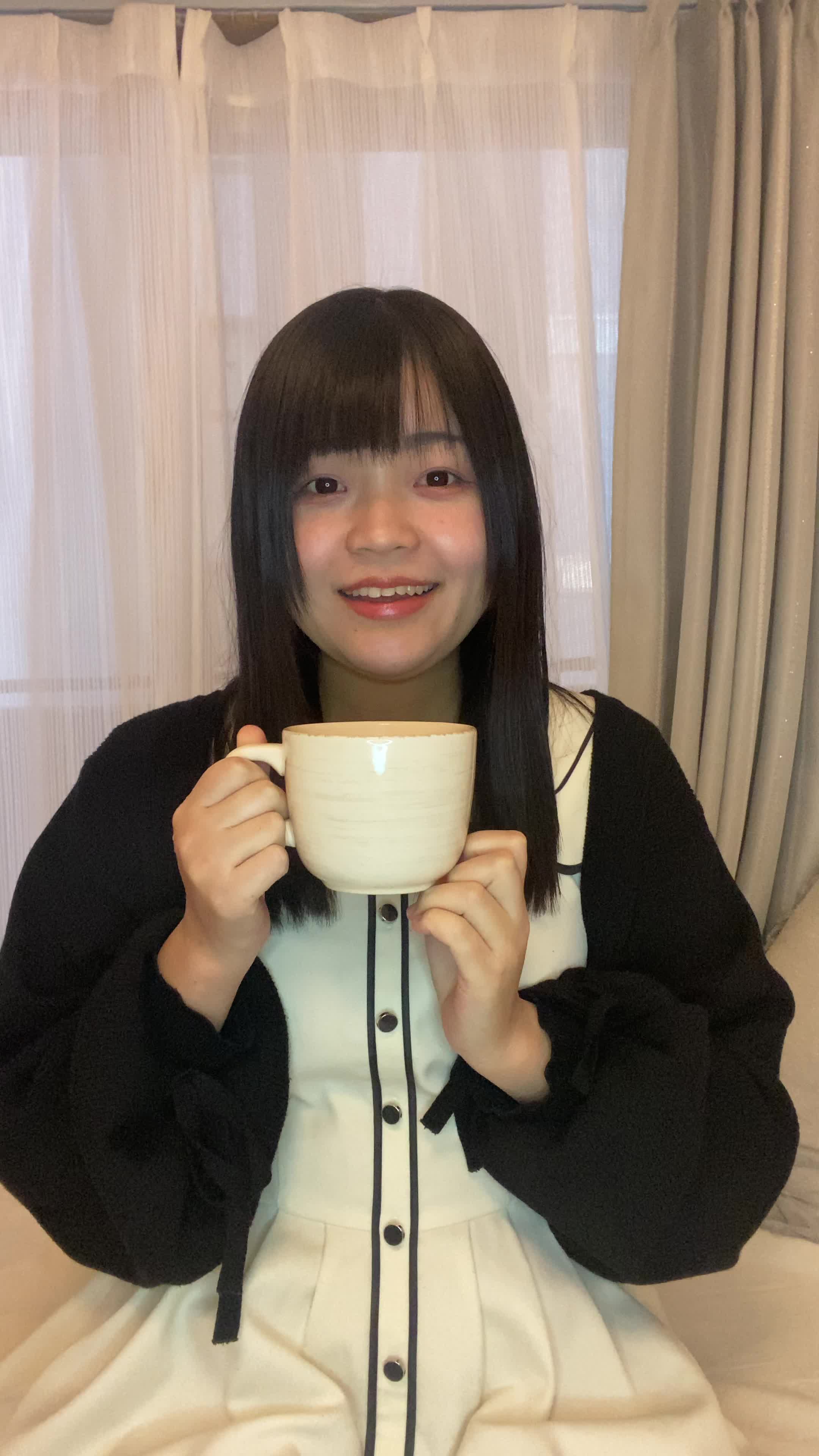 ソファでカップを手に、「次の白髪ケア商品を試す楽しみ」を思い浮かべる表情