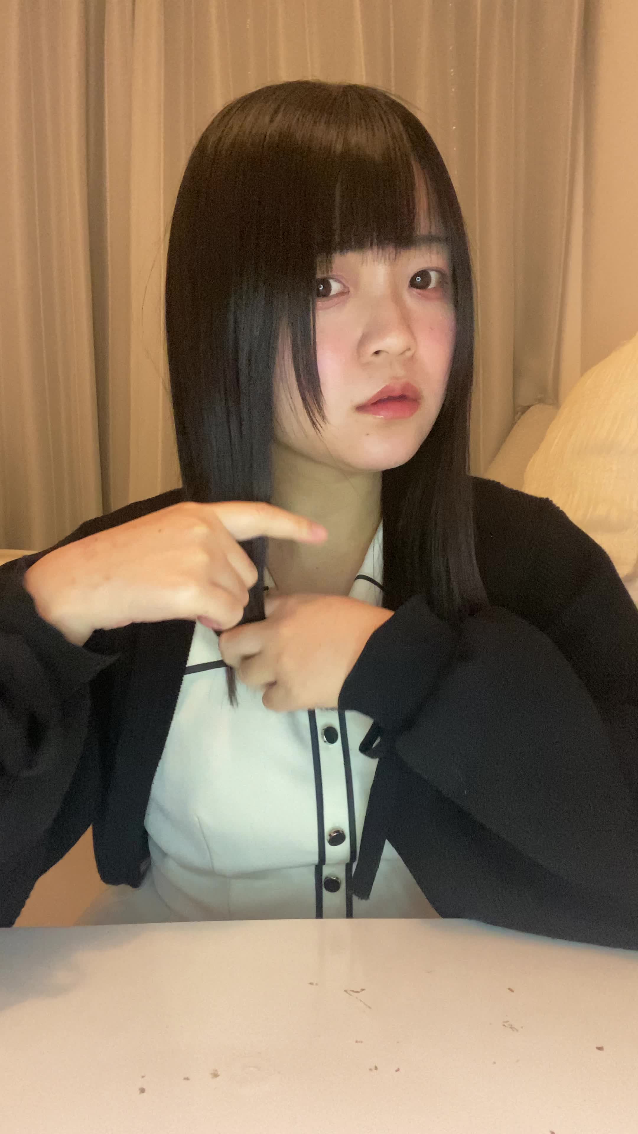 テーブルで髪を手に取り、「白髪部分をどうケアしよう」と計画する真剣な表情