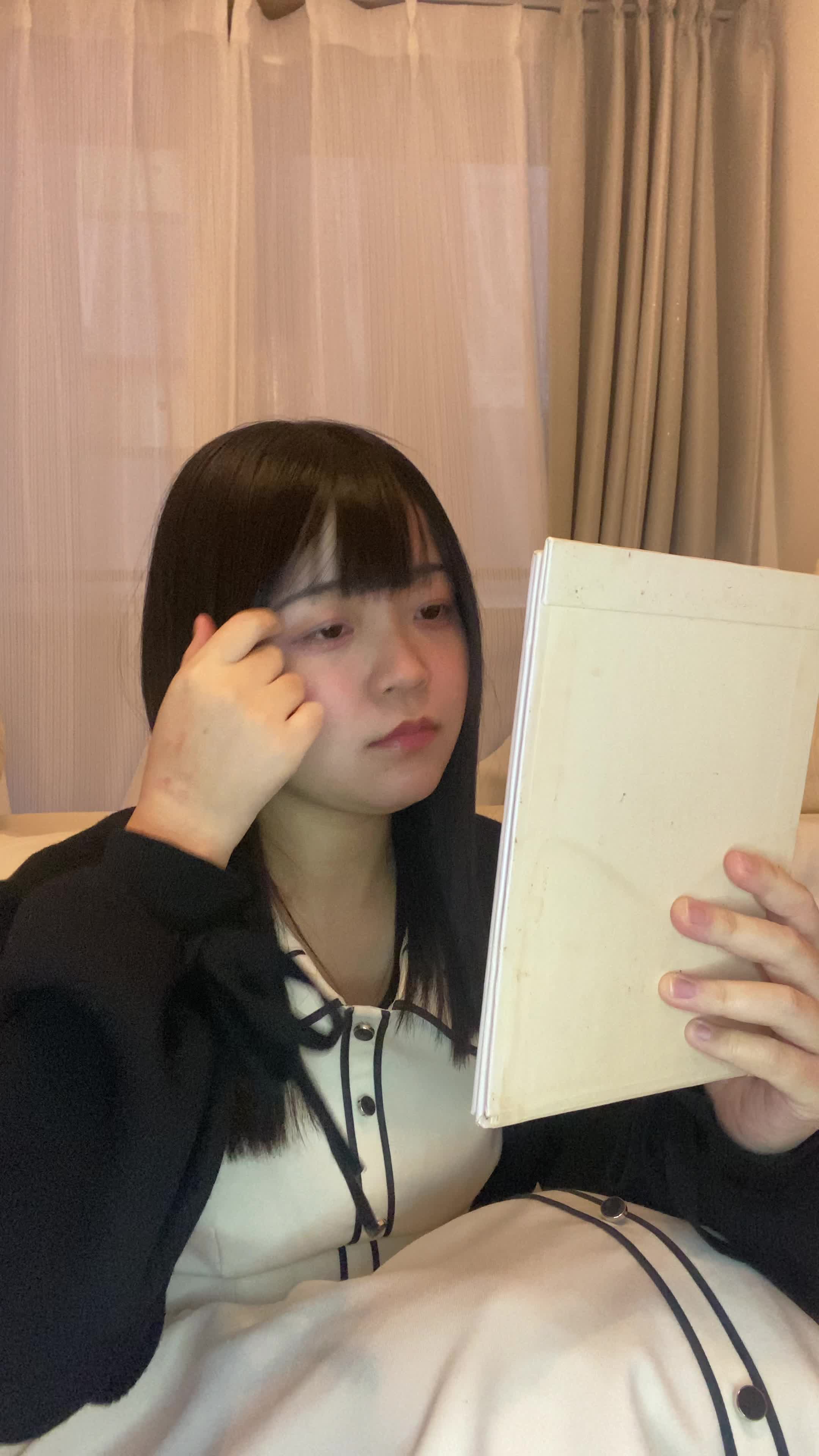 床に座り込み、鏡を近づけて白髪をじっくり確認し、「これがなくなれば…」と考える仕草