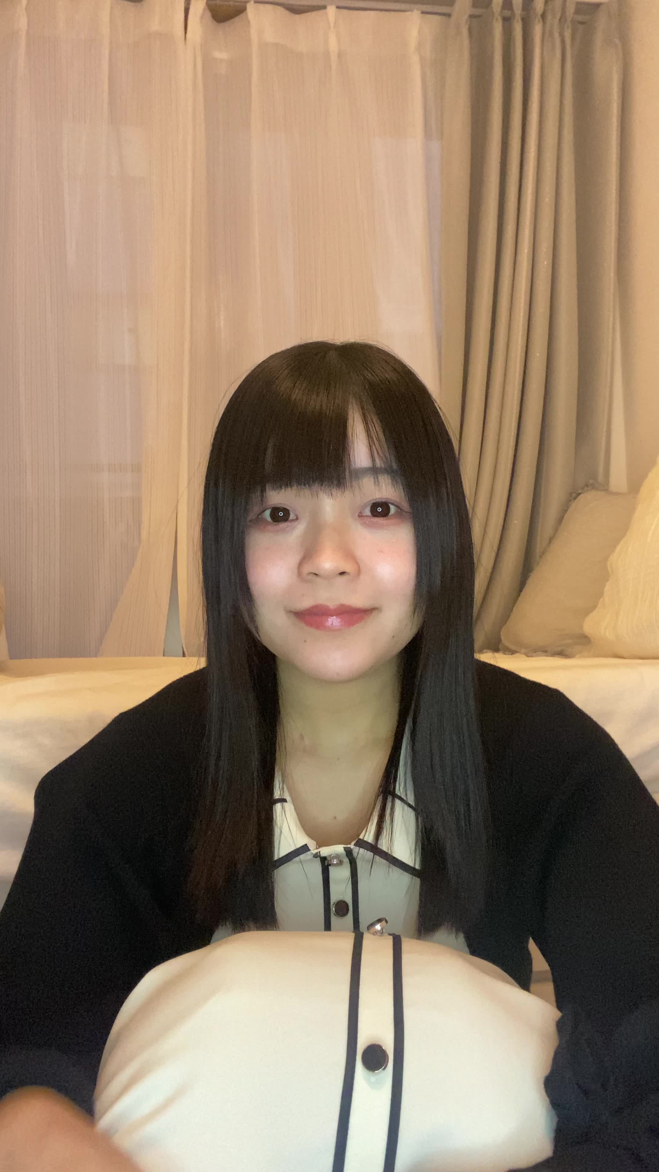 床で膝を立てて座り、「この白髪ケア商品を試してみようかな」と期待を込める動作