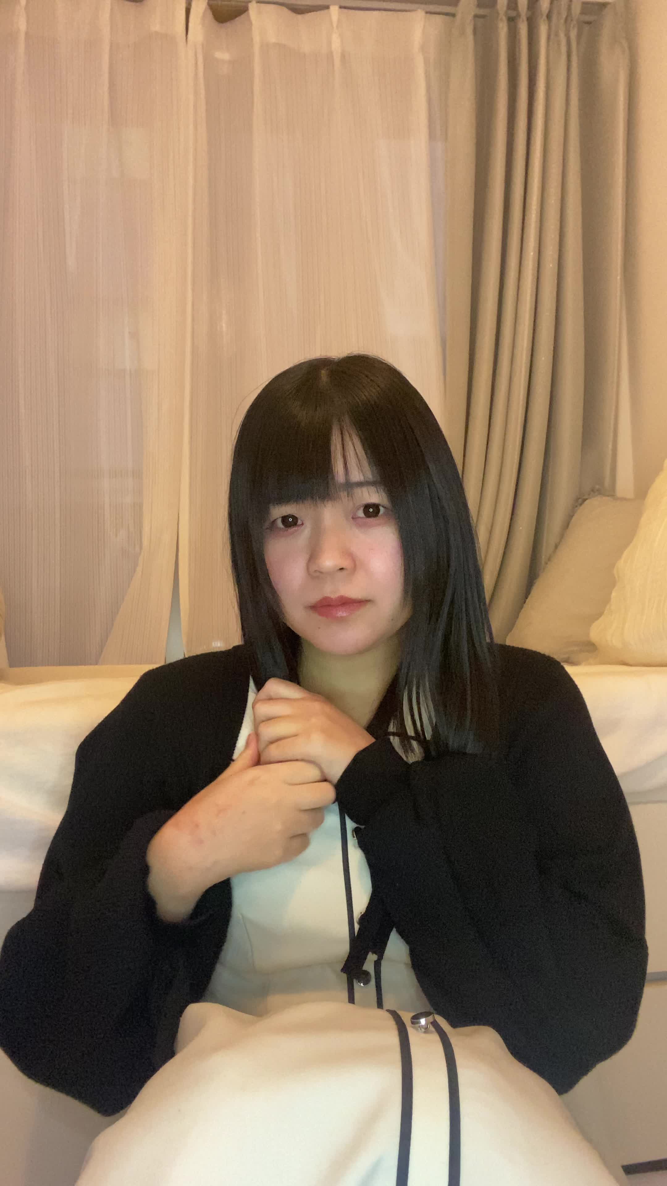 床で白髪を手で隠して、「もっと若々しく見える方法を考える」動作