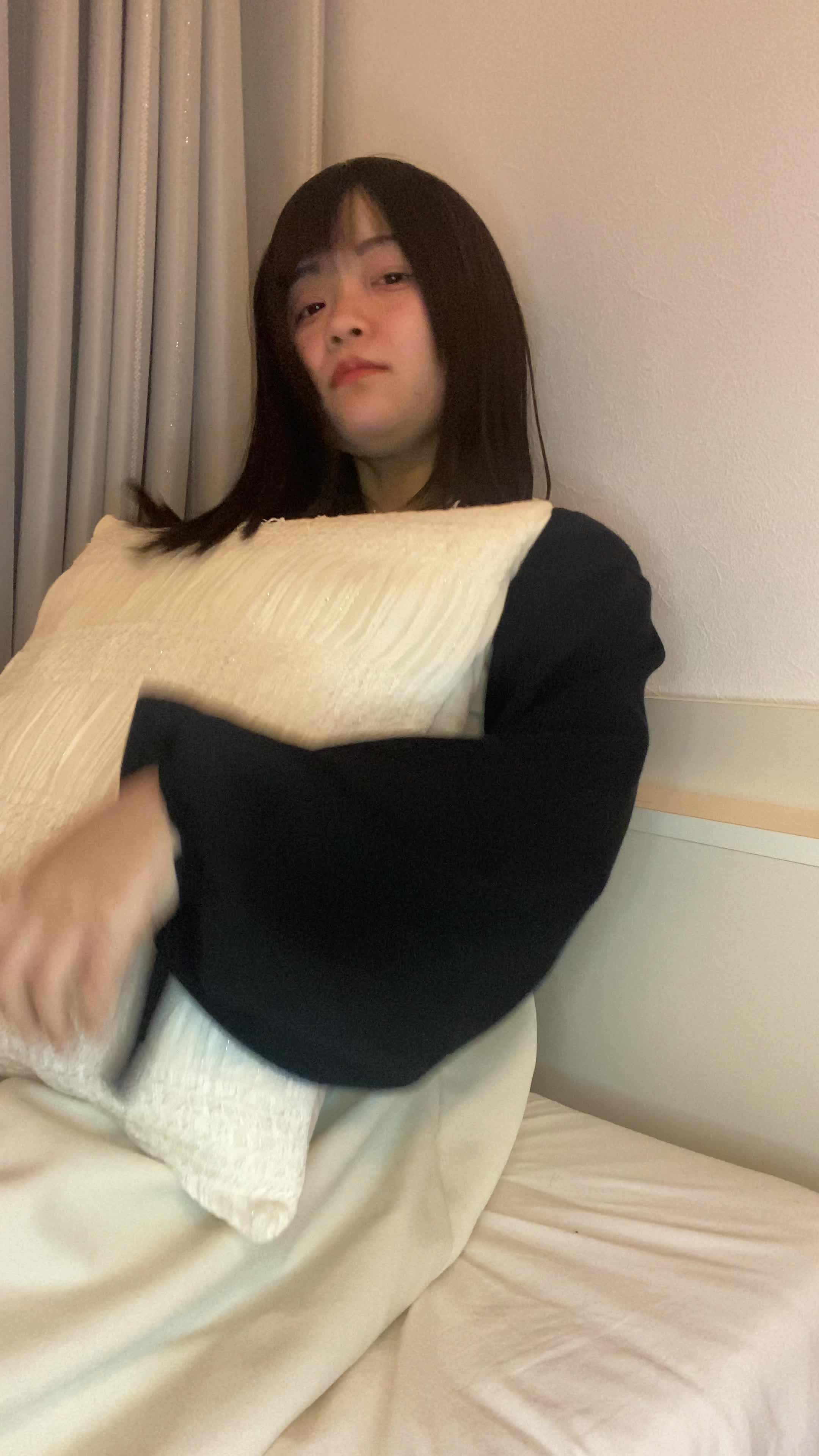 ベッドでクッションを抱えて、「白髪がなくなったらこんなことがしたい」と夢見る表情