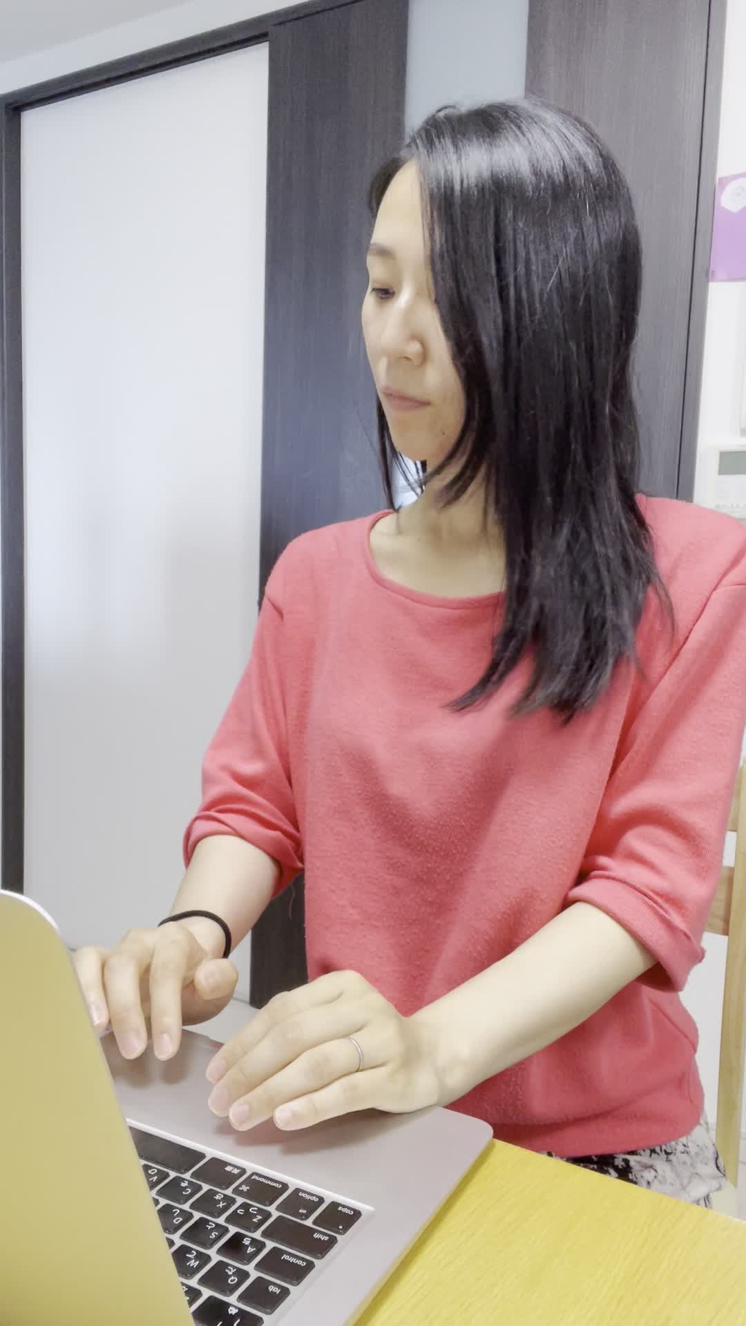 椅子に座り、仕事中にスマホを確認し、メッセージが来てにやけてしまう様子