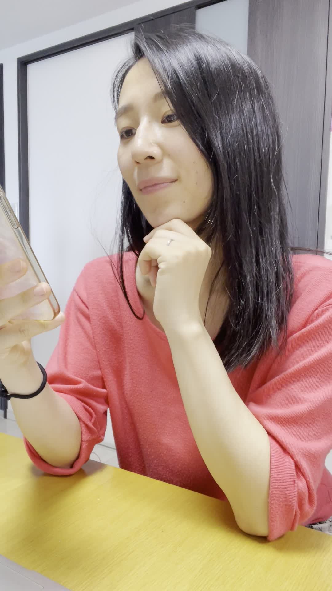 椅子に浅く腰掛け、スマホを握りしめながら「次のメッセージ、早く来ないかな」と待つ動作