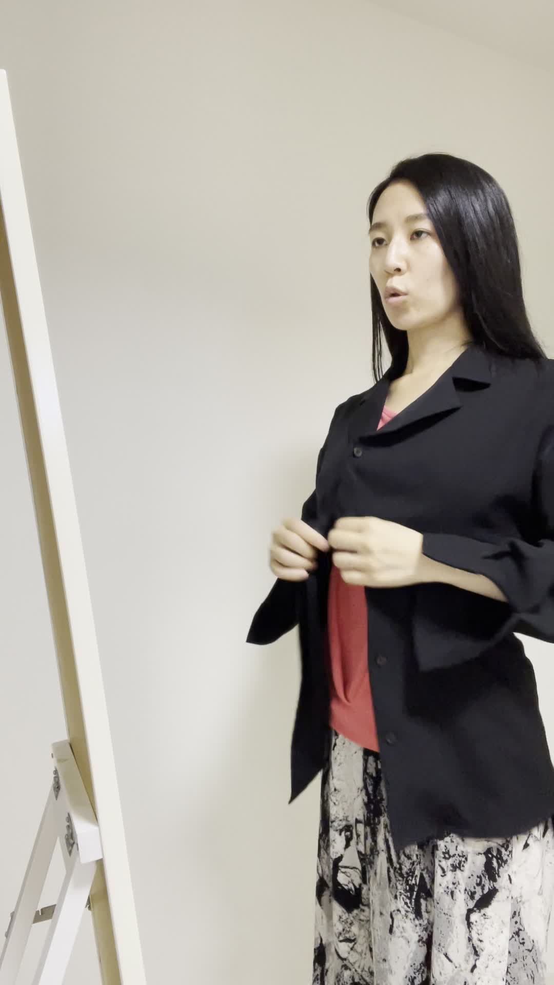 鏡の前でコートを羽織り、「これで大丈夫かな？」と確認する姿