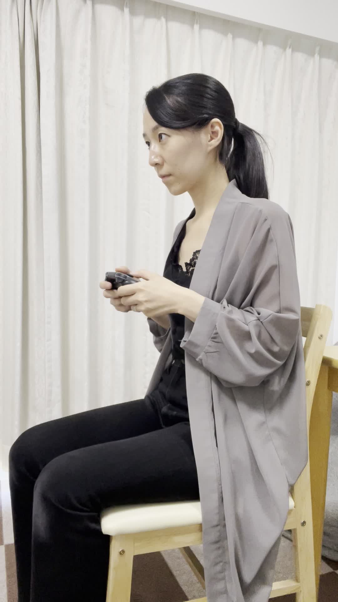 椅子に座り、コントローラーを握りしめ、画面に向かって熱中する姿