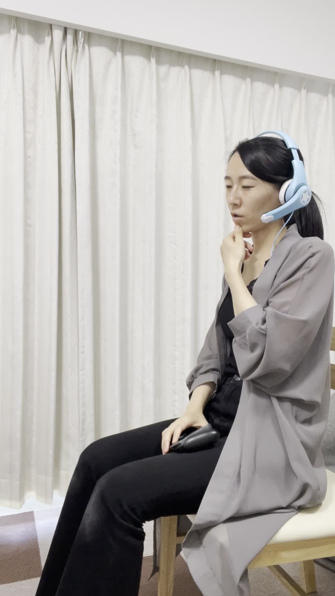 椅子に深く腰掛け、ヘッドセットをつけて「仲間とボイスチャットで作戦を話し合う」動作