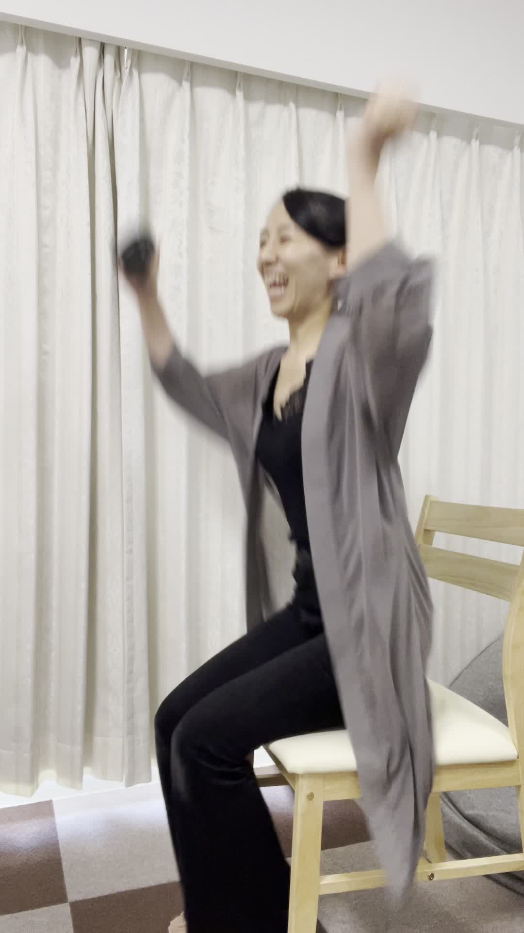 椅子から立ち上がり、「勝利の瞬間」に両手を高く上げて喜ぶ動作