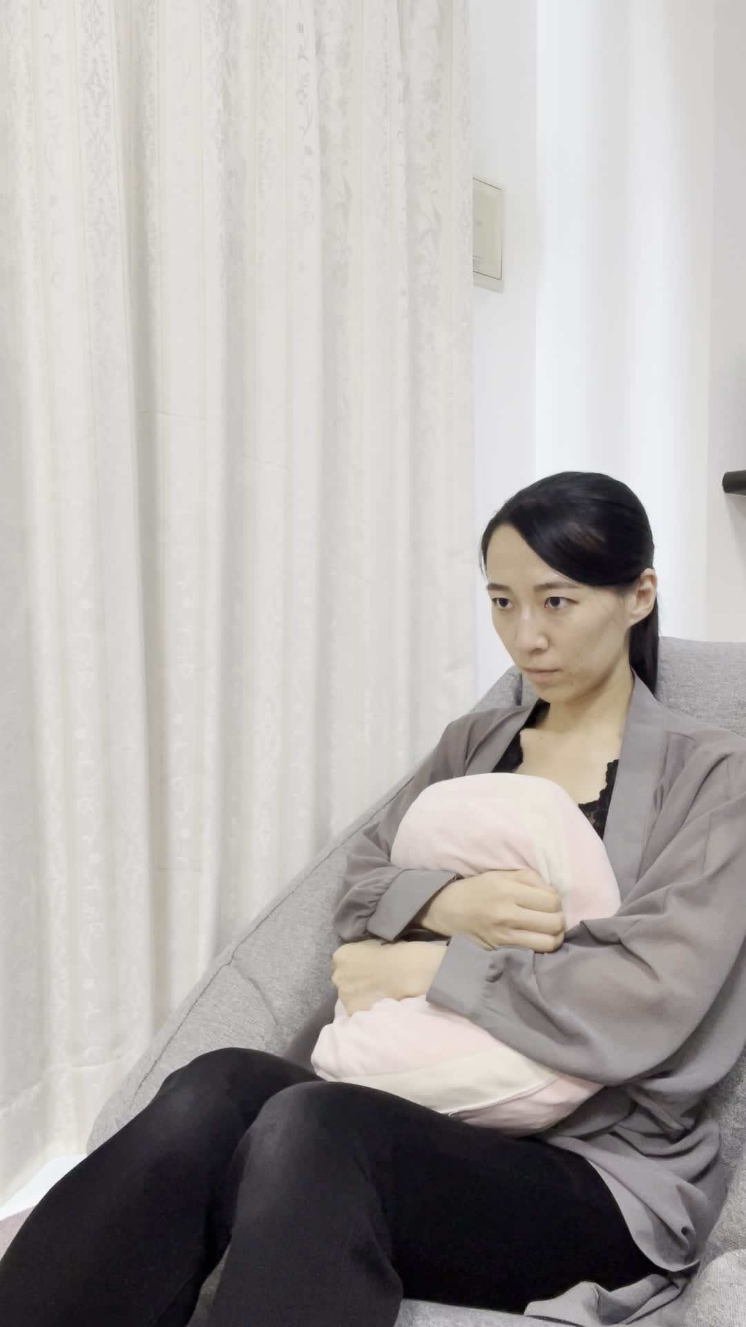 ソファでクッションを抱きながら、「あと少しで勝てる！」と真剣な表情を見せる動作