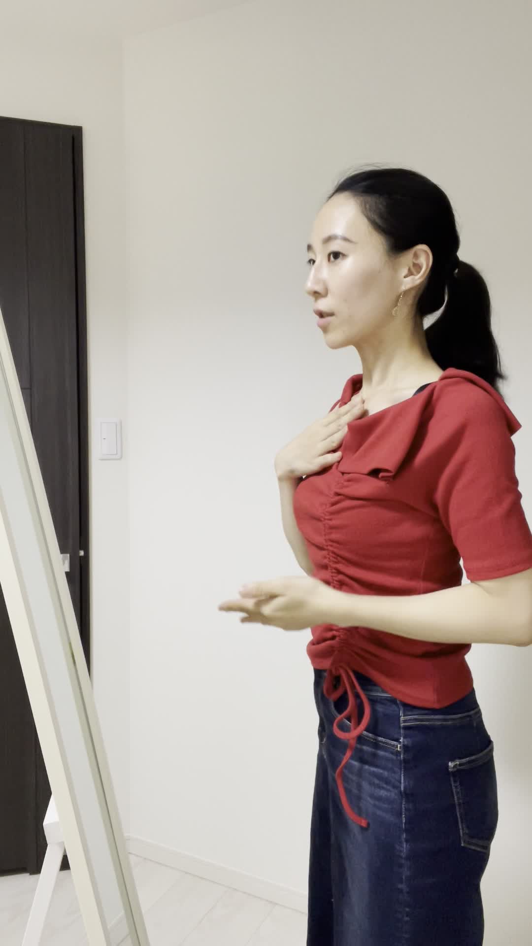 鏡の前で英語のスピーチを練習しながら身振り手振りを加える仕草