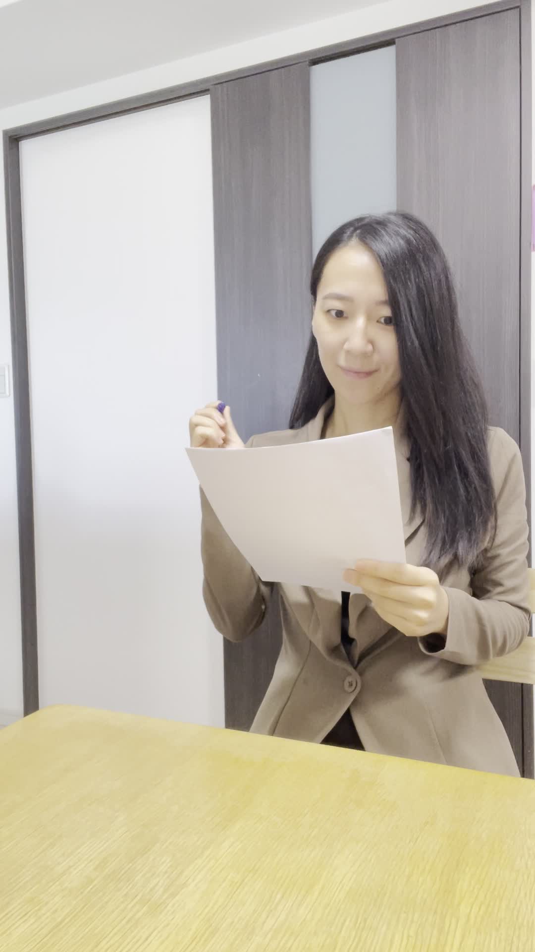 椅子に腰掛け、書類にチェックを入れながら「これで安心できる」と確認する姿